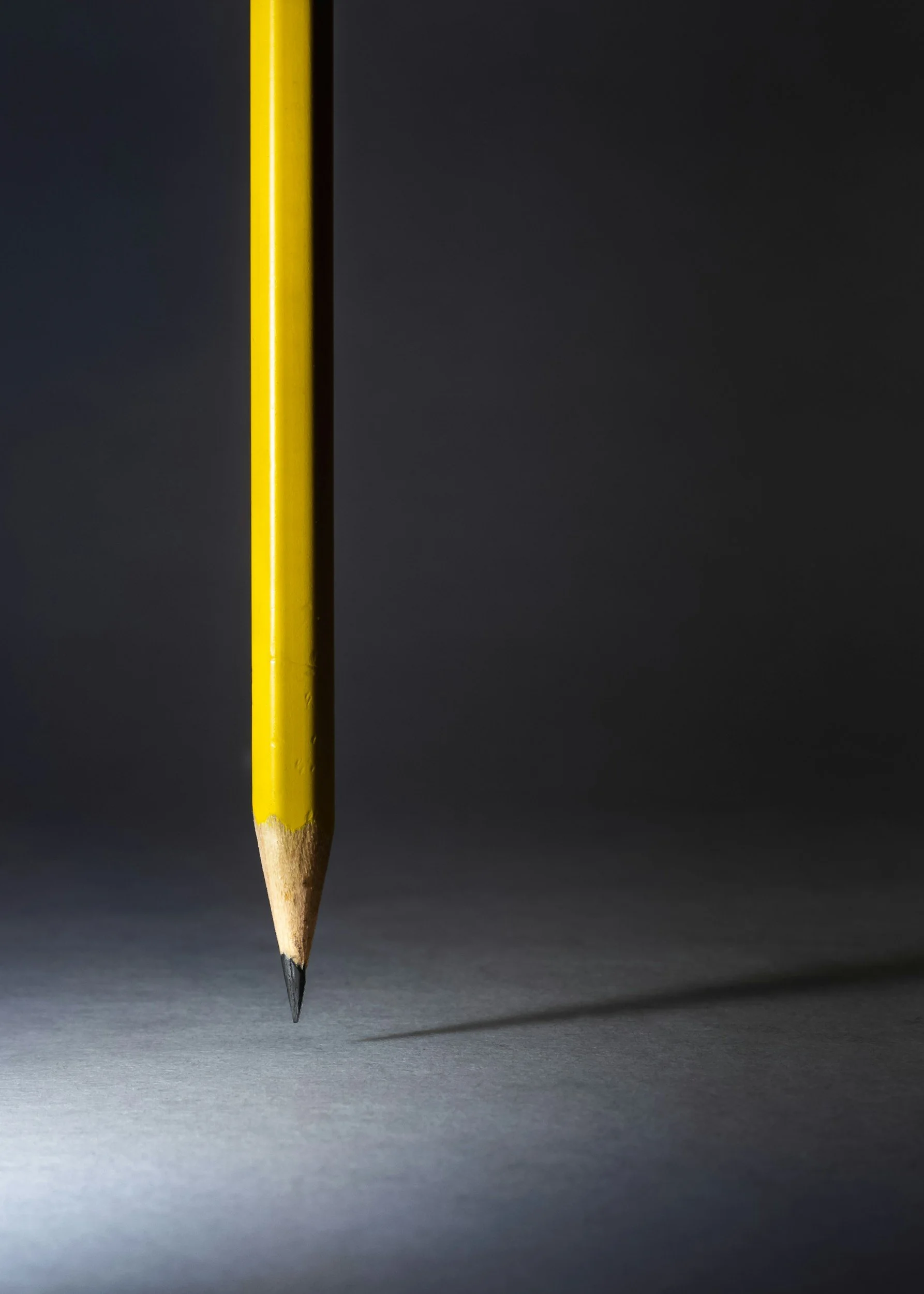 pencil standing upright on dark background