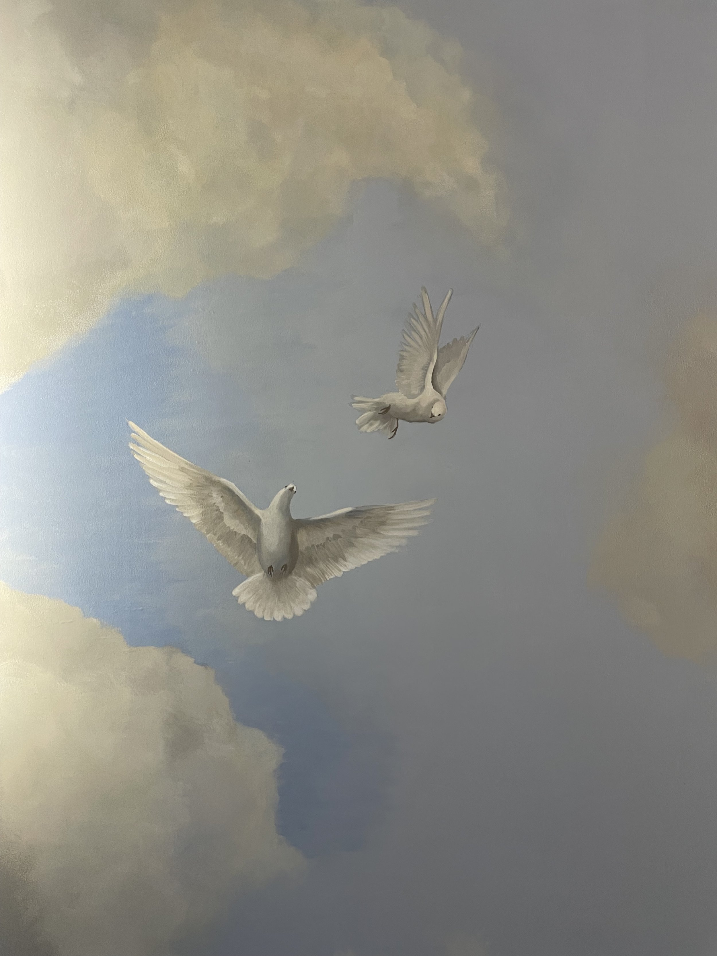 Fine art mural painting of two white doves flying in a sky with clouds in historic downtown Charleston, SC by local artist Gabrielle Hasenstab