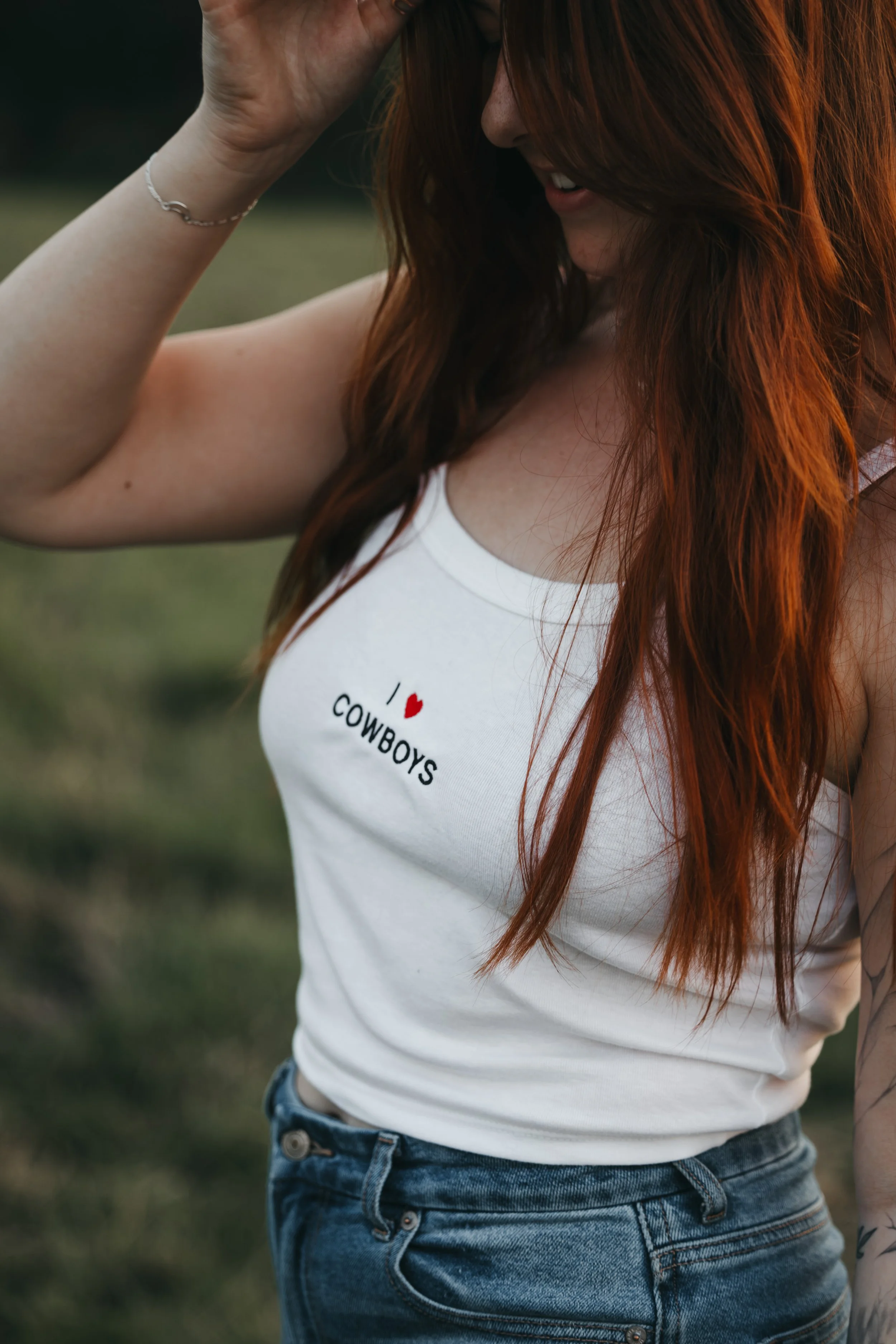 Girl wearing an Embroidered tank top that says I love cowboys