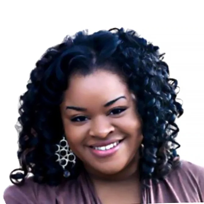A smiling woman with curly black hair wearing earrings and a brown top.
