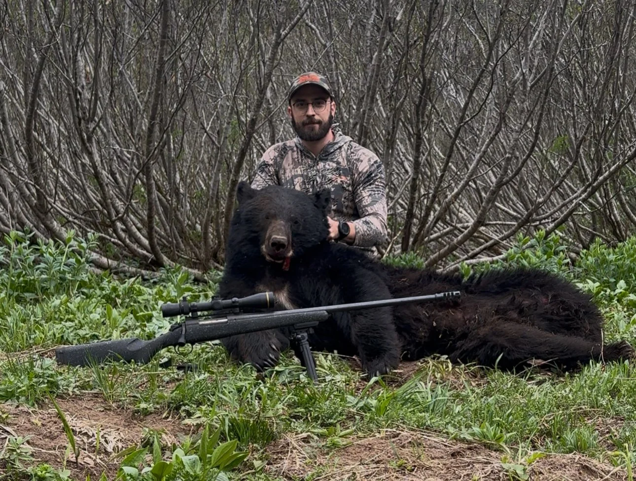 A hunter with a harvested black bear.