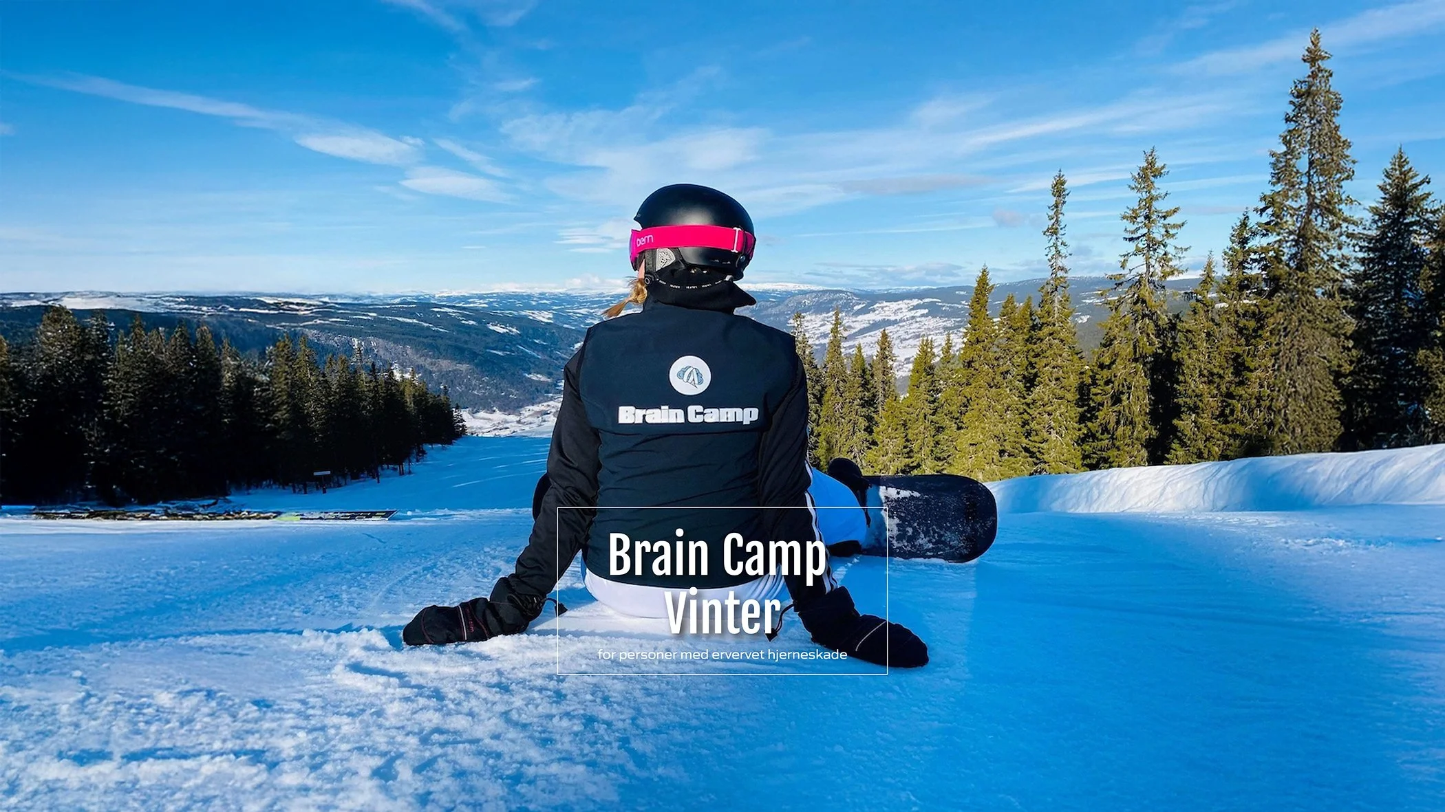 Person som sitter i snøen med snowboard på bena