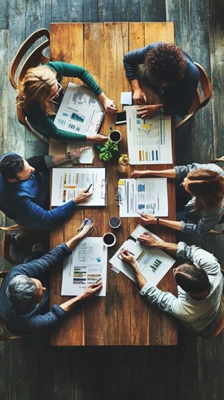 Several people sitting at a table and discussing seperate issues which appear when you buy a house