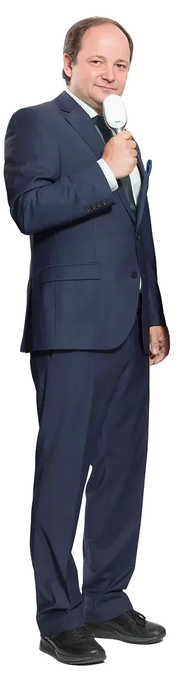 Ein Mann als Moderator in einem dunklen eleganten Anzug hält ein Telefon an das Ohr und lächelt.