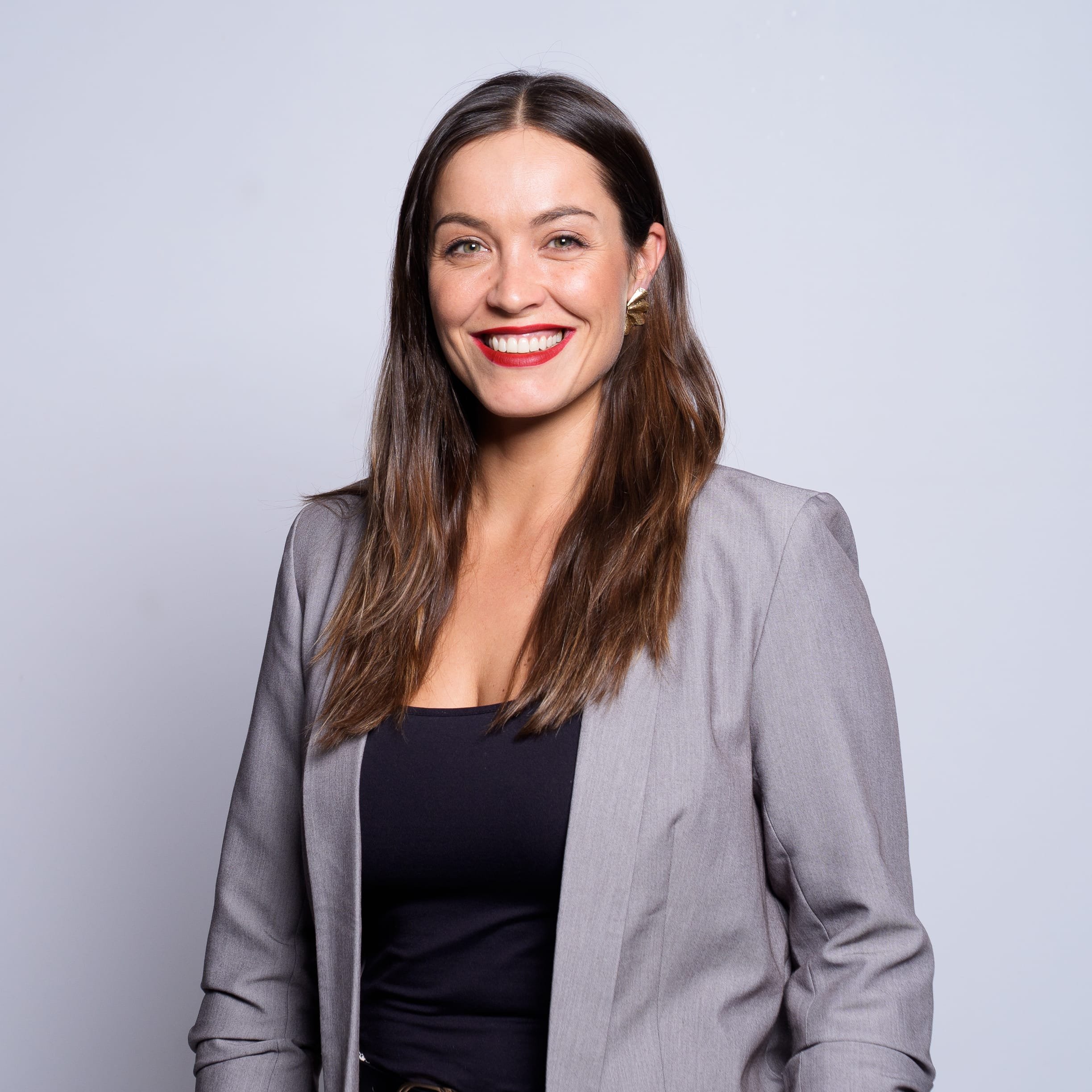 Donna sorridente con capelli castani e vestito nero.