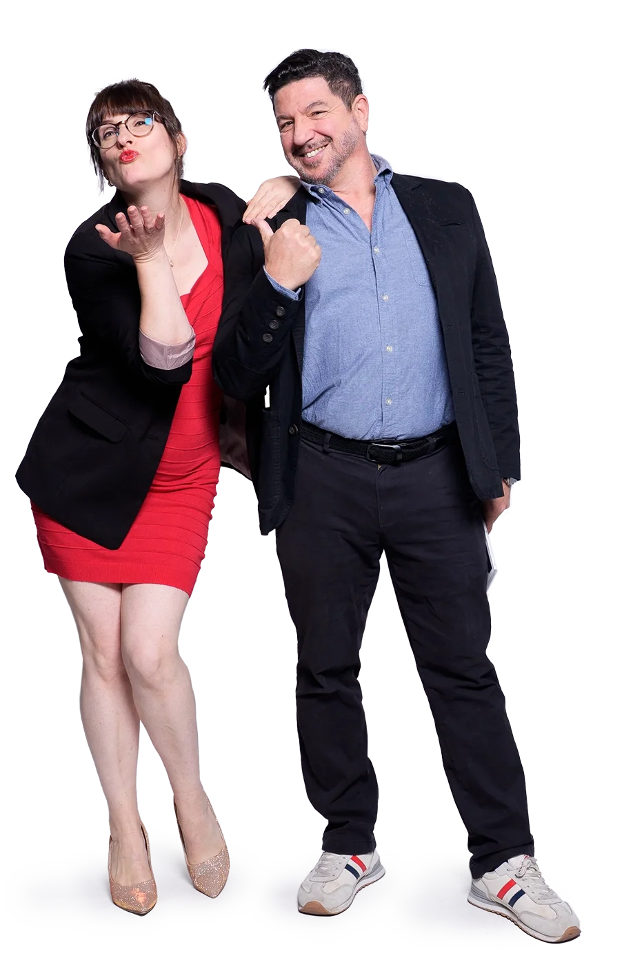 Ein Mann und eine Frau als Überraschungsgäste stehen nebeneinander, lächeln und scheinen Spaß zu haben. Der Mann trägt eine blaue Hemd und schwarze Hosen, die Frau trägt ein rotes Kleid und eine schwarze Jacke.