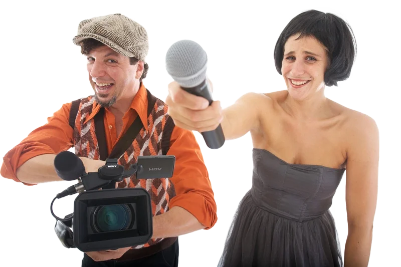 Ein Mann mit Kamera und eine Frau, die in die Kamera lächelt humorvoll und ein Mikrofon hält, vor weißem Hintergrund.