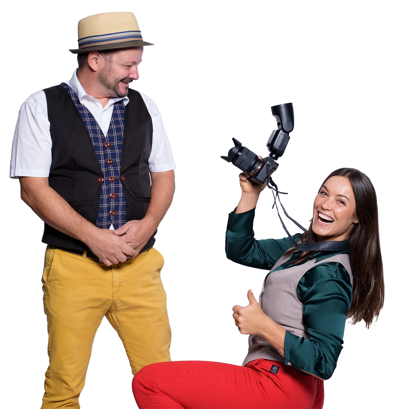 Zwei lachende Menschen, eine Frau mit einer Kamera und ein Mann stehen vor einem weißen Hintergrund.