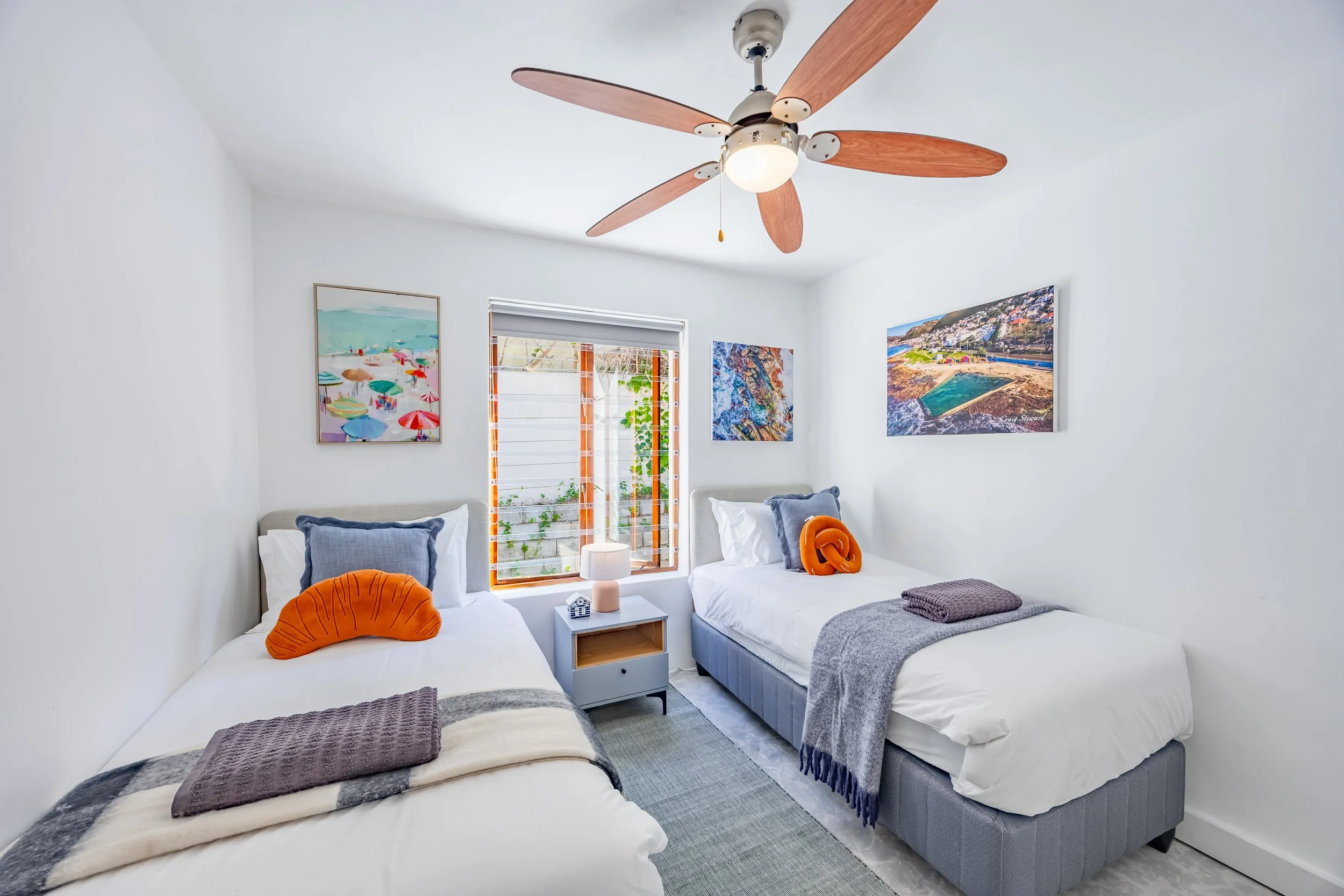 Bright twin bedroom in a St James holiday apartment, photographed to showcase the colourful interior styling, comfortable accommodation and natural light.