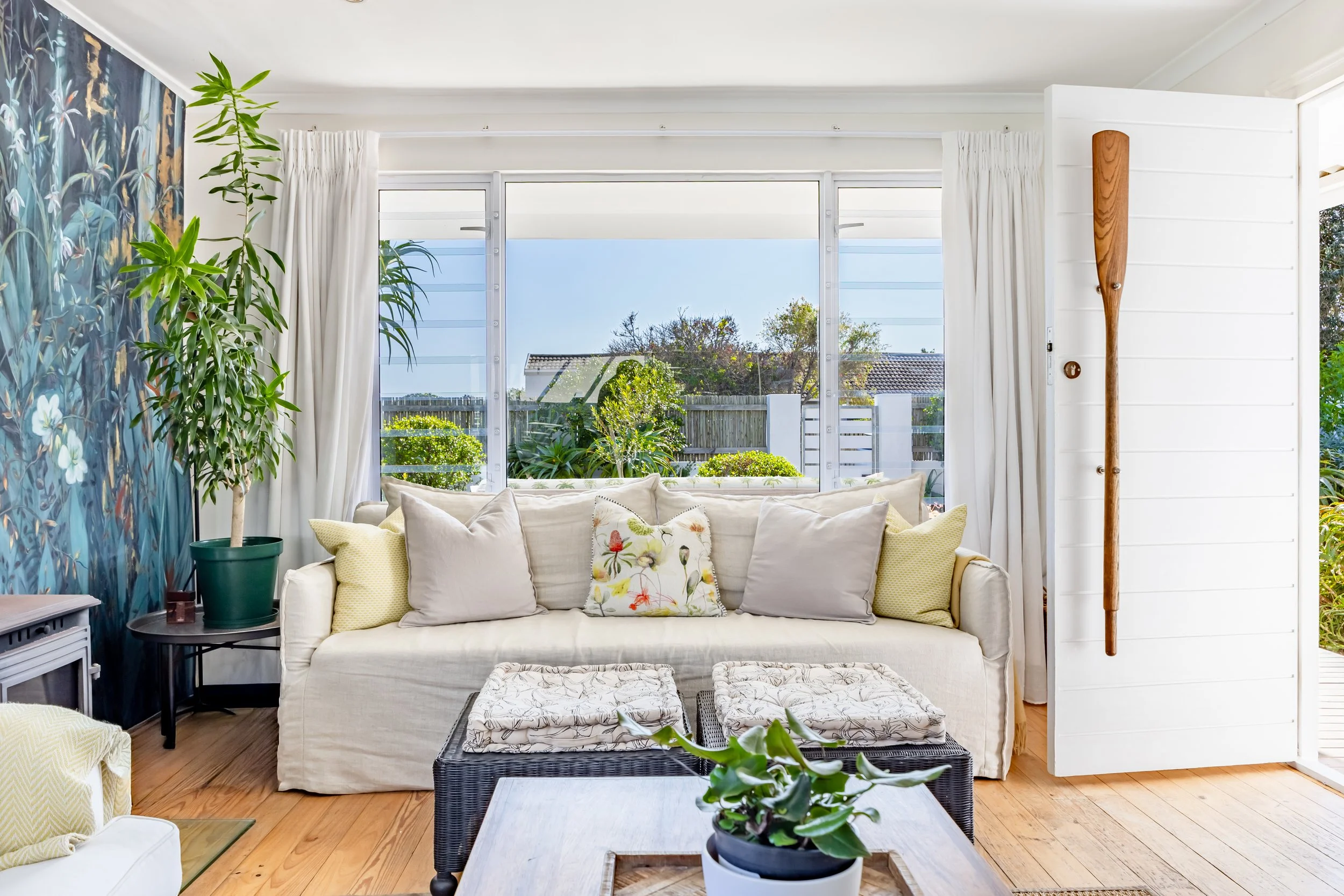 Bright coastal living room with large windows and ocean views, professionally photographed for an Airbnb and holiday rental property in Cape Town.