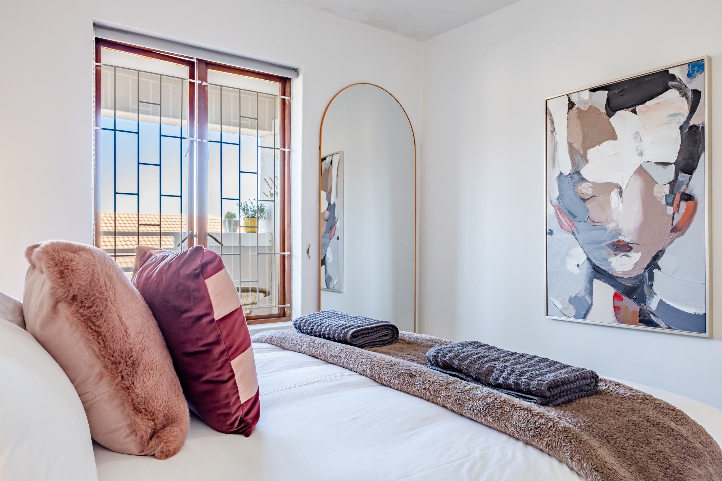 Bright main bedroom in a Kalk Bay holiday apartment, photographed to showcase the colourful interior styling, comfortable accommodation and natural light. MadEye Photography