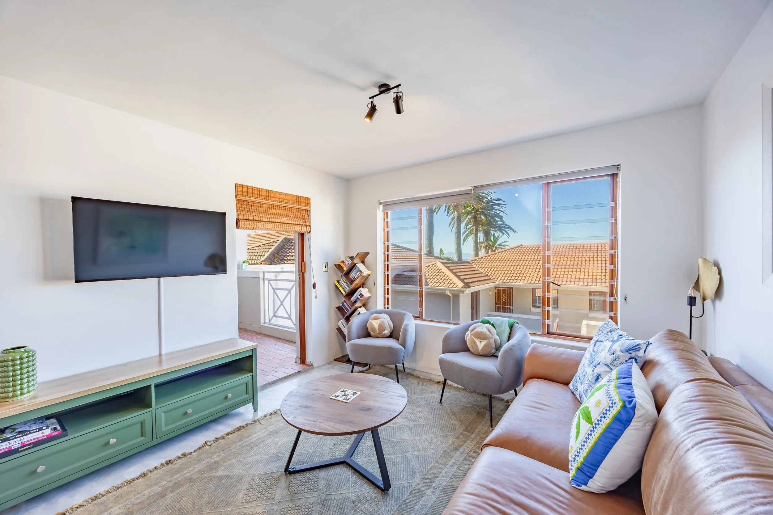 Bright, coastal living room at a St James Terrace holiday apartment in Cape Town, photographed by MadEye Photography for professional Airbnb and hospitality property photography.