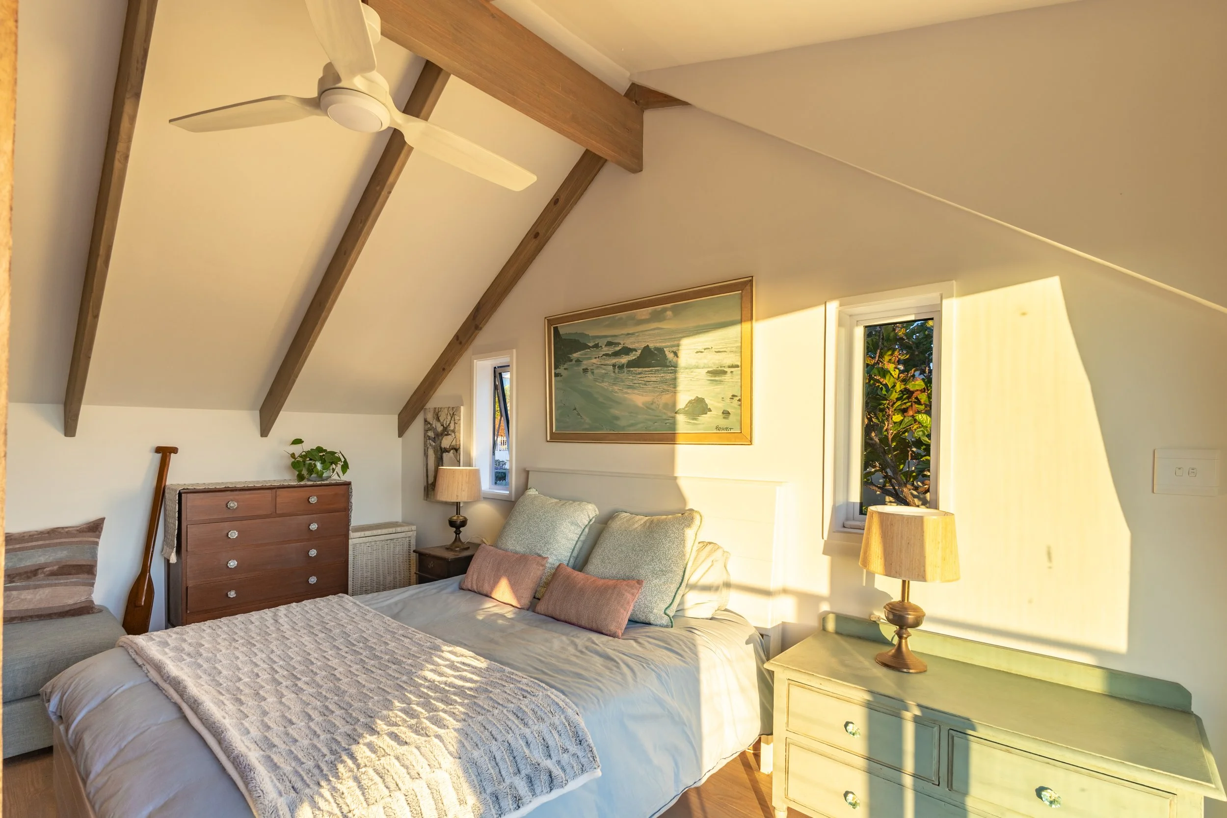 Sunlit loft-style bedroom with exposed beams photographed for a luxury Airbnb accommodation in Cape Town.