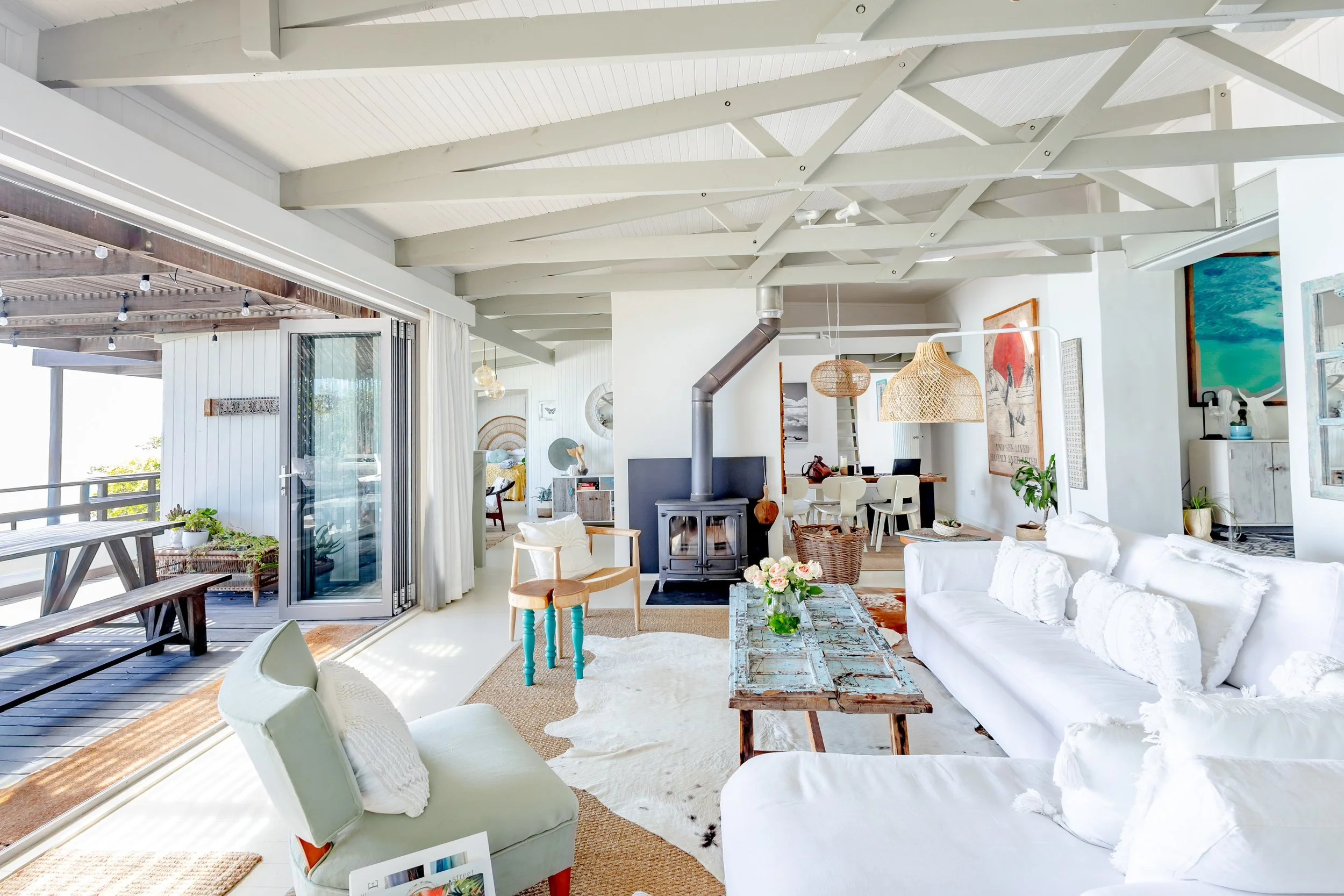 Sun-drenched lounge featuring a wood-burning fireplace, cowhide rug, and views of the Misty Cliffs coastline.