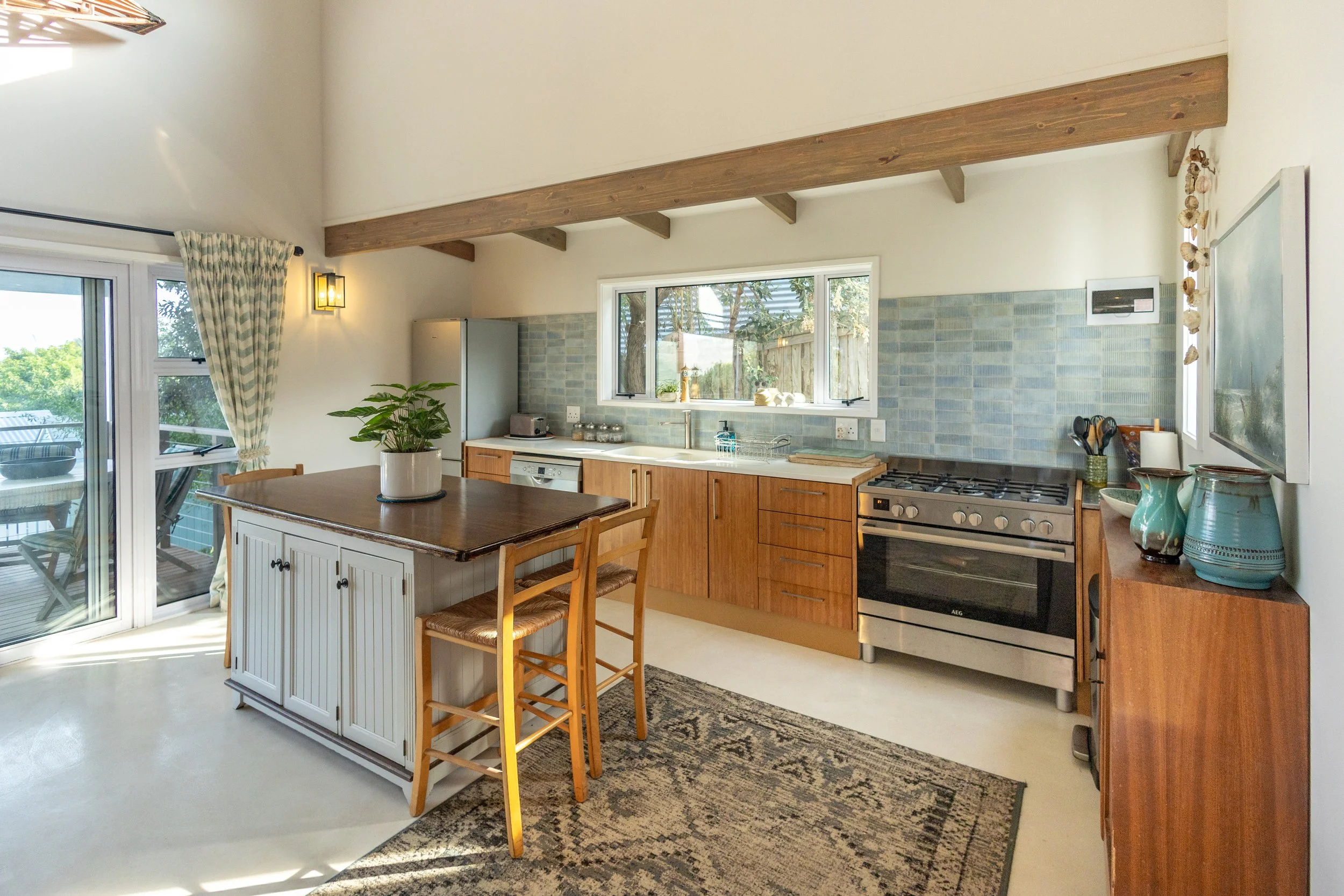 Bright open-plan kitchen with exposed wooden beams professionally photographed for an Airbnb and residential property in Cape Town.