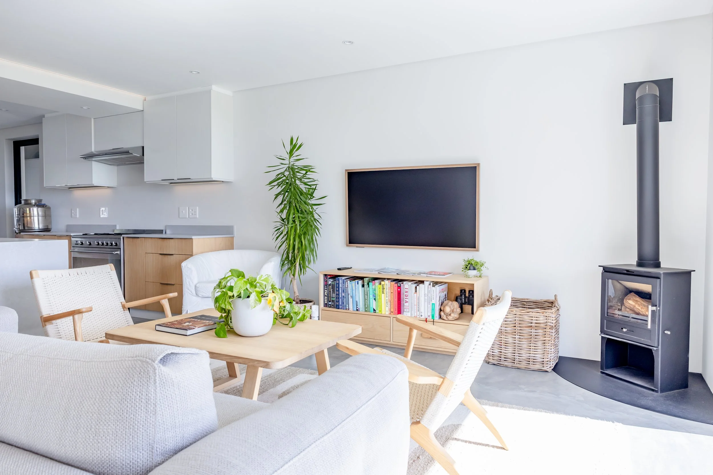 Modern Sea Point apartment interior highlighting a clean living area with a flat-screen TV and Scandinavian-style wooden furniture.