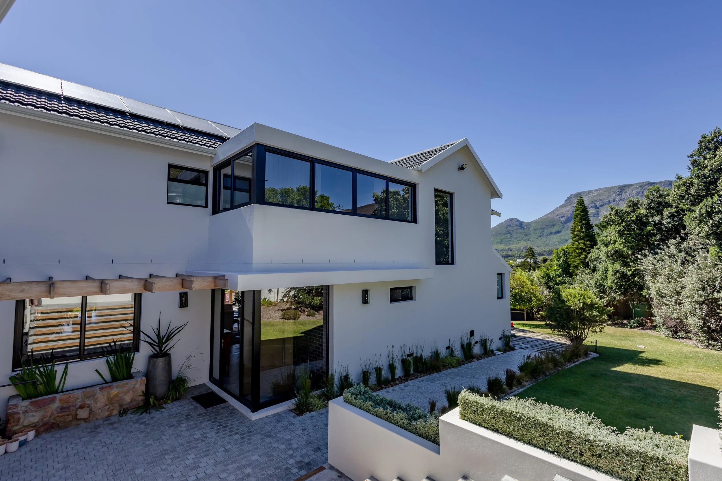 Architectural photography of a contemporary Llandudno beach house with expansive glass windows and clean white exterior lines.