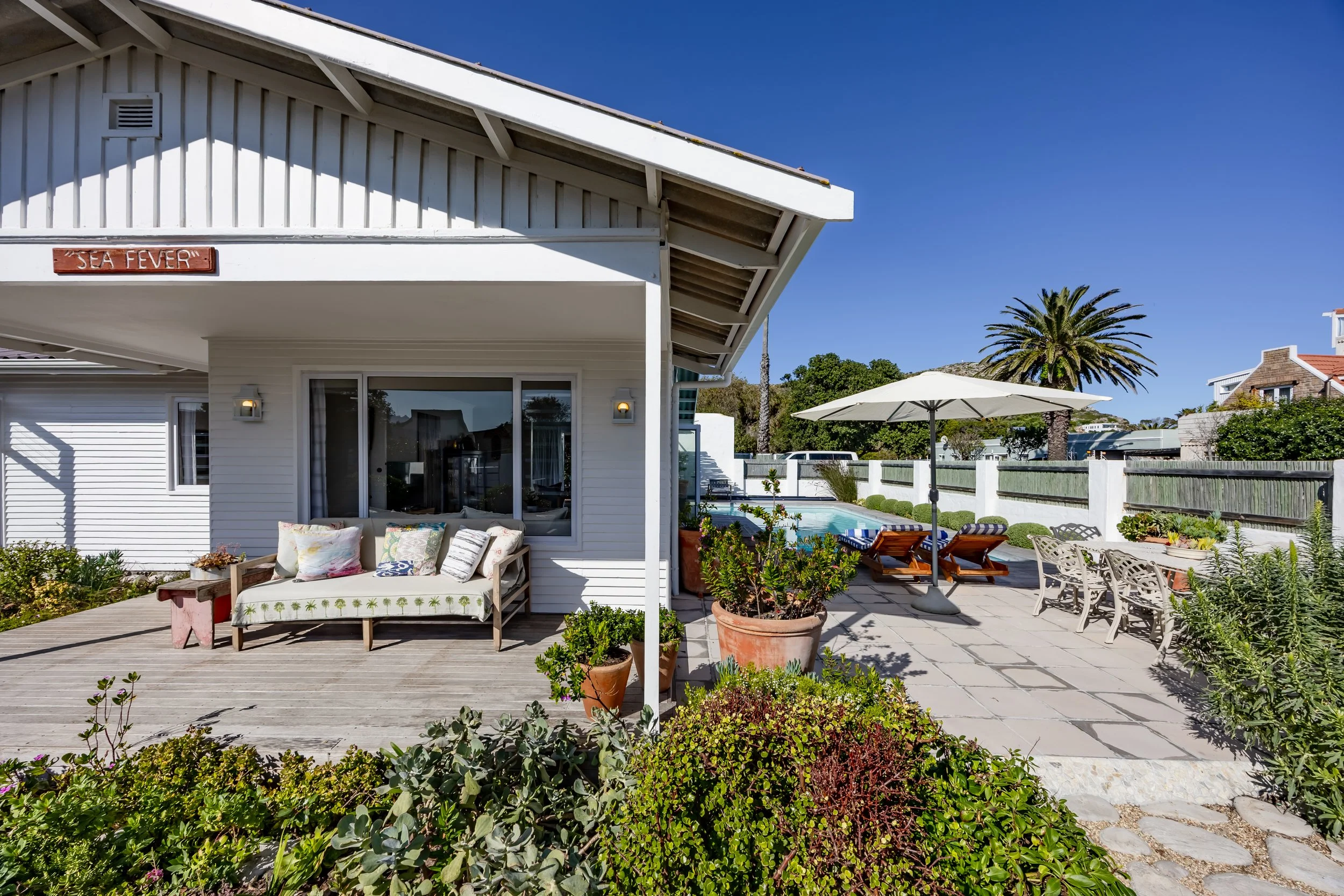 Exterior view of a modern coastal home with outdoor living space and landscaped garden, captured for professional residential photography in Cape Town.