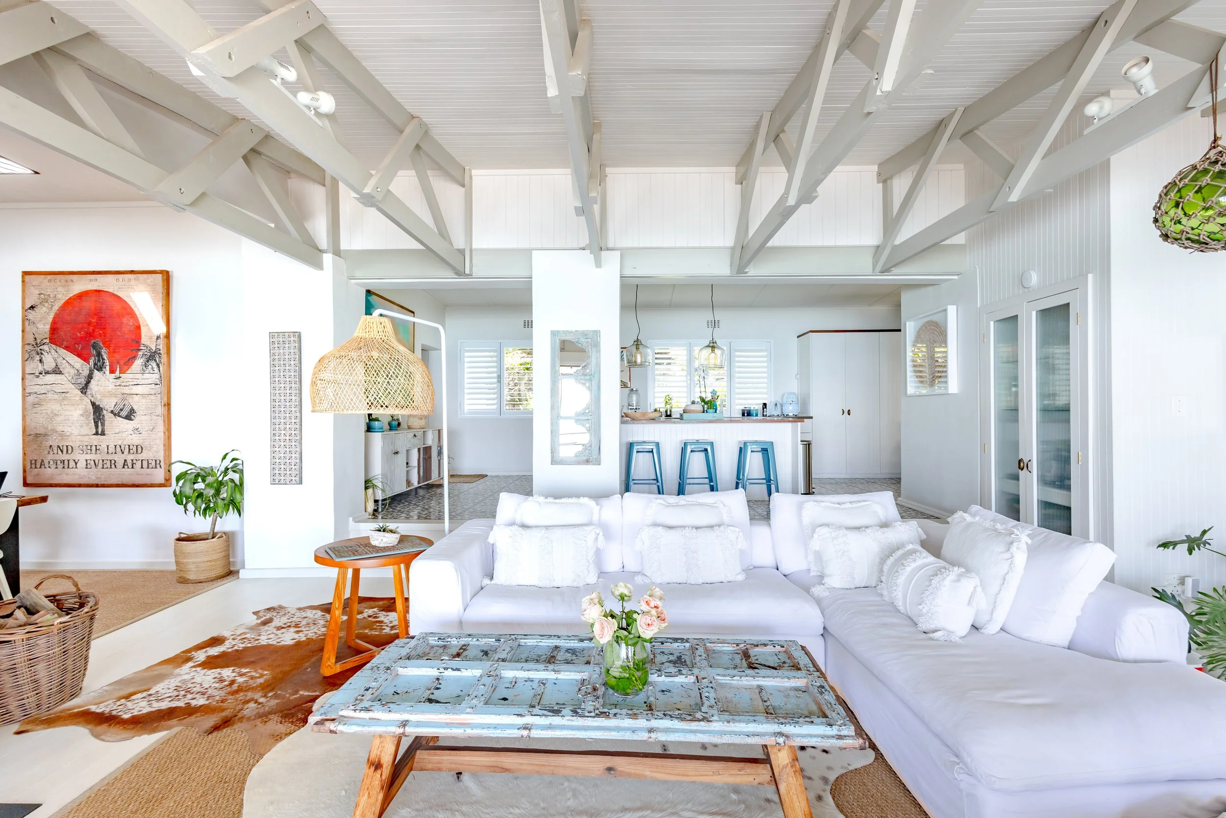 Airy beach house interior with a white sectional sofa, vaulted ceilings, and coastal decor in Cape Town.