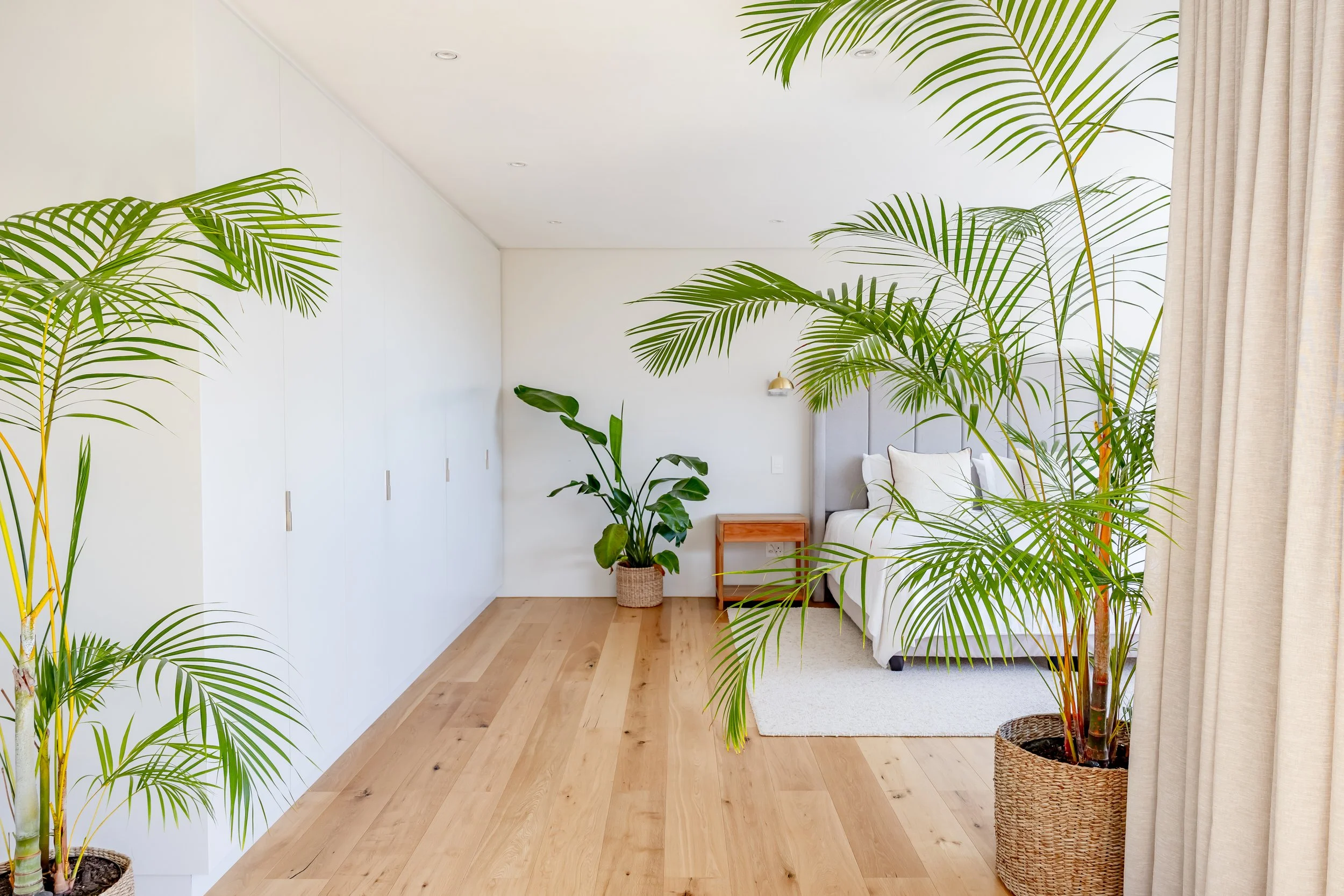 Bright, minimalist guest bedroom interior in Cape Town featuring light wood flooring and natural light, professionally shot for an Airbnb portfolio.