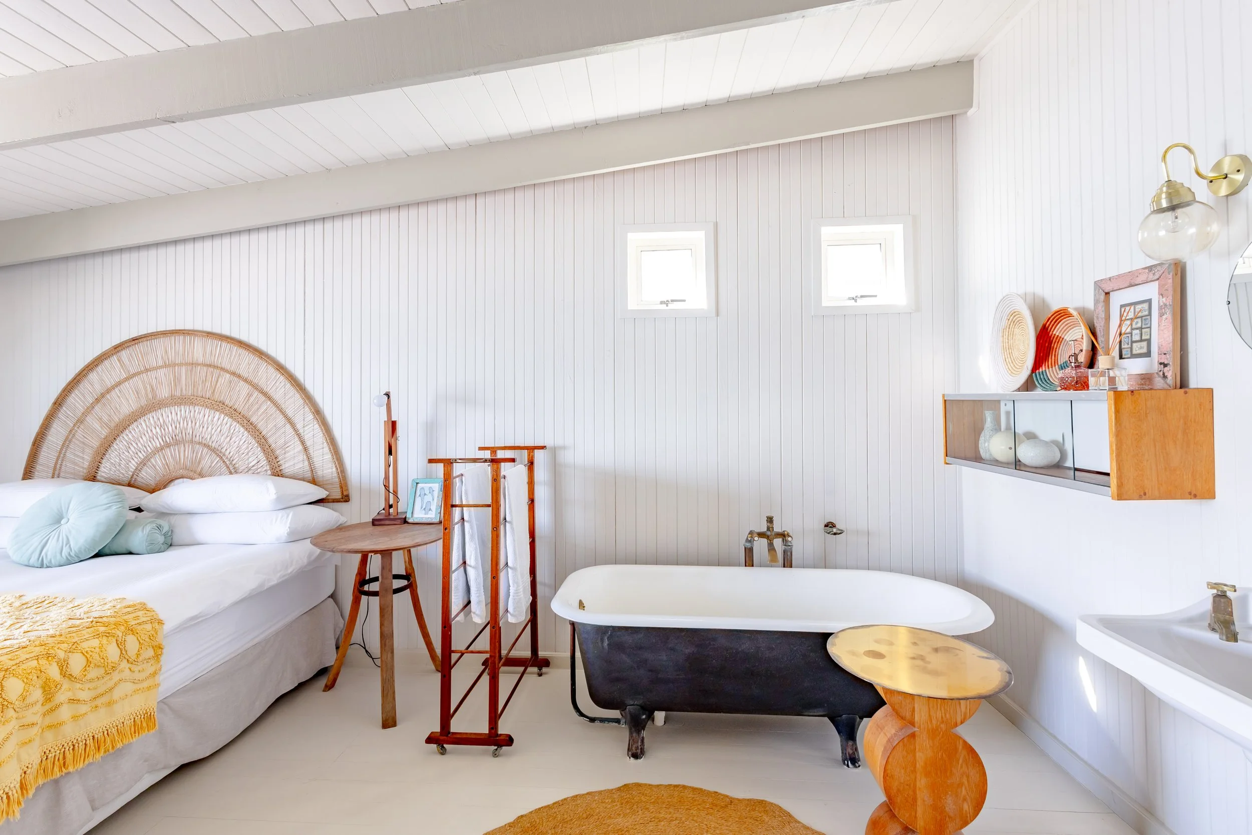 Luxury bathroom featuring a vintage-style black clawfoot bathtub and white wood-paneled walls.