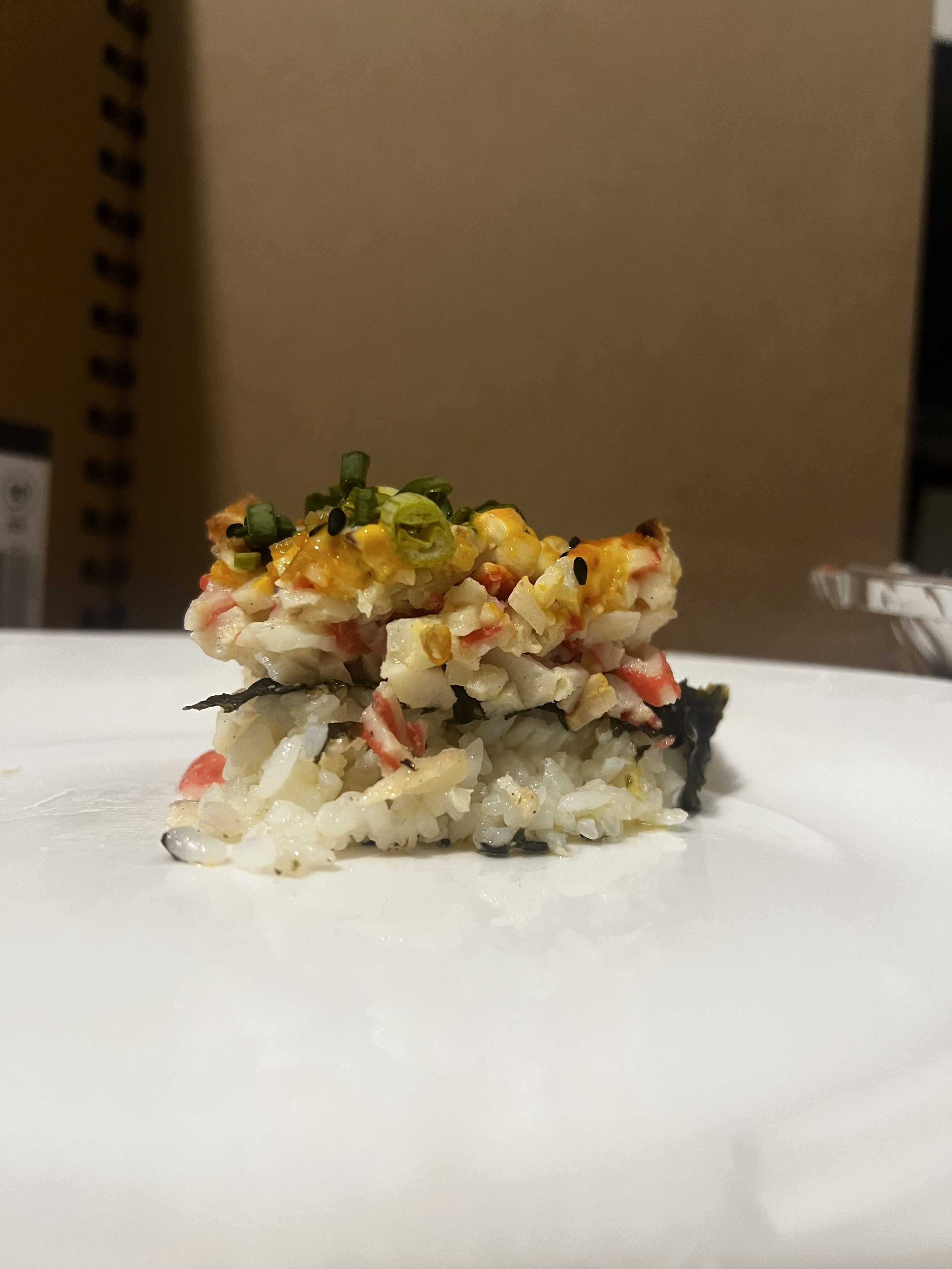 Bird's eye view of a crabmeat sushi bake in foil container