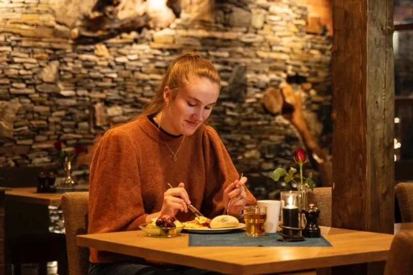 Woman enjoying breakfast in atmospheric Flåm Restaurant