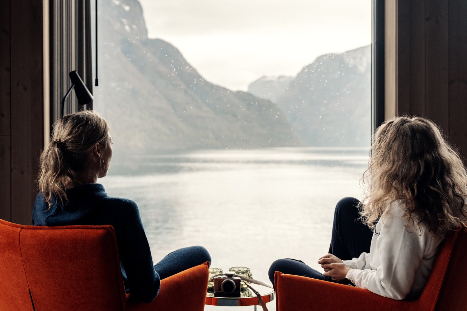 Two girls enjoying the fjord view from Wangen Apartments in Aurland
