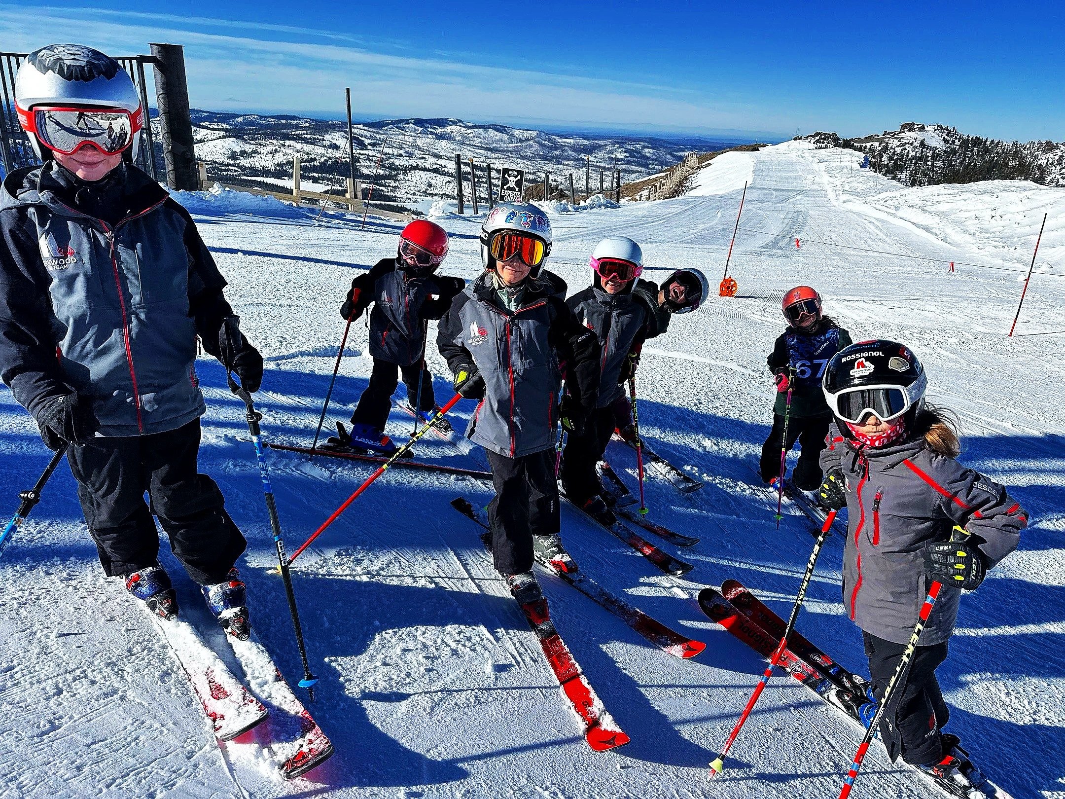 Young Kirkwood Ski Education Foundation skiers gathered on a sunny slope with mountain views
