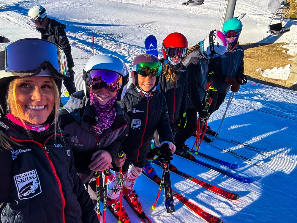 KSEF coach and young athletes smiling together in helmets and goggles on snow
