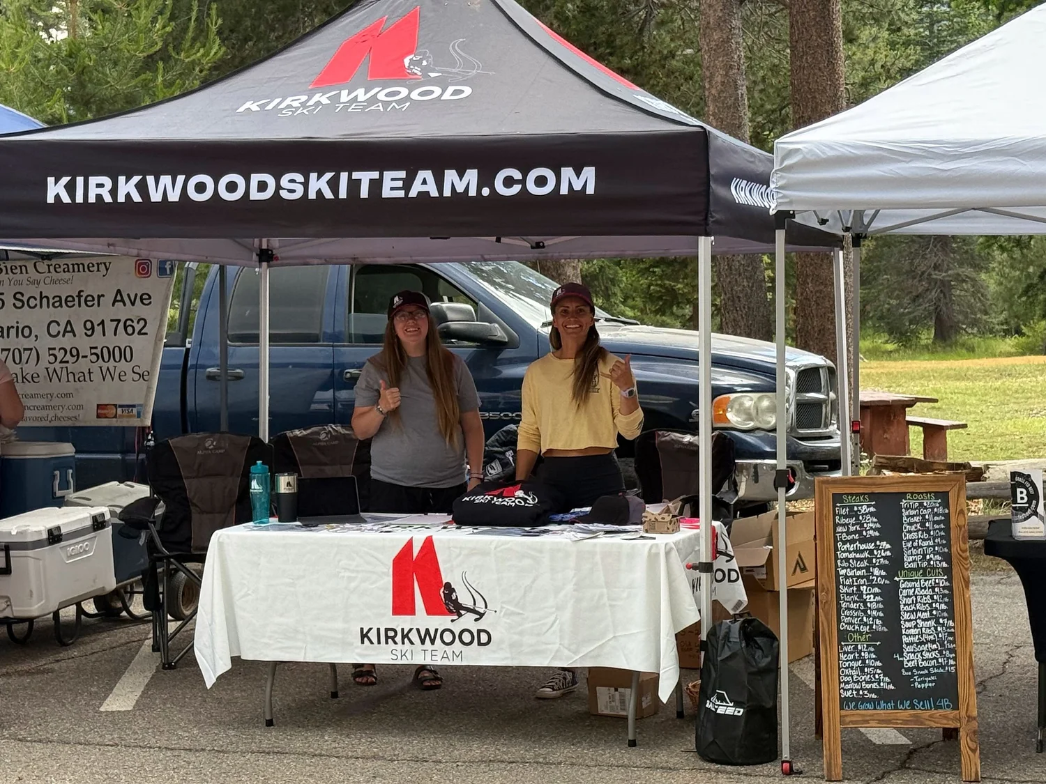 Kirkwood Ski Team staff welcoming families at the KSEF community event booth under a kirkwoodskiteam.com tent