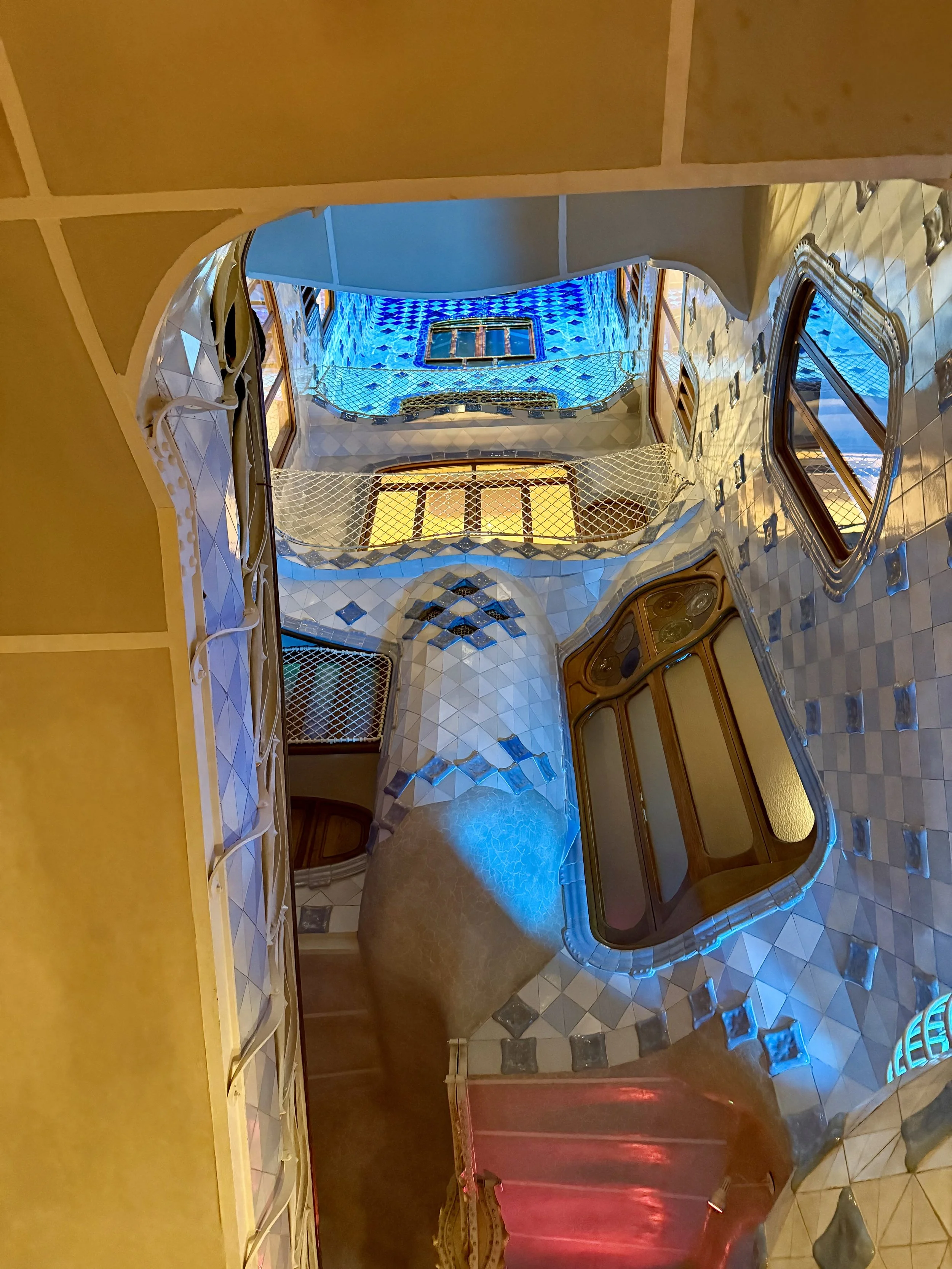 Casa Batlló interior atrium with blue stained glass ceiling and curved walls
