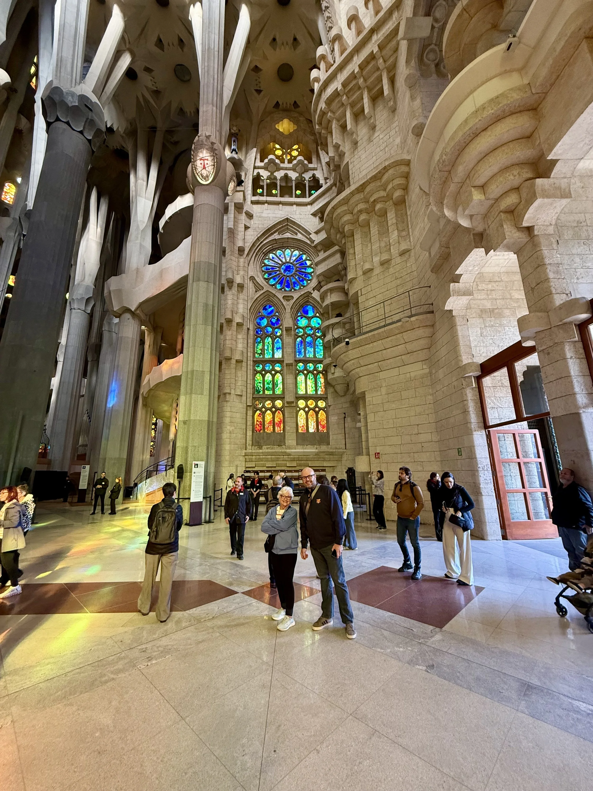 Sagrada Família interior nave with branching stone columns and colored stained glass light
