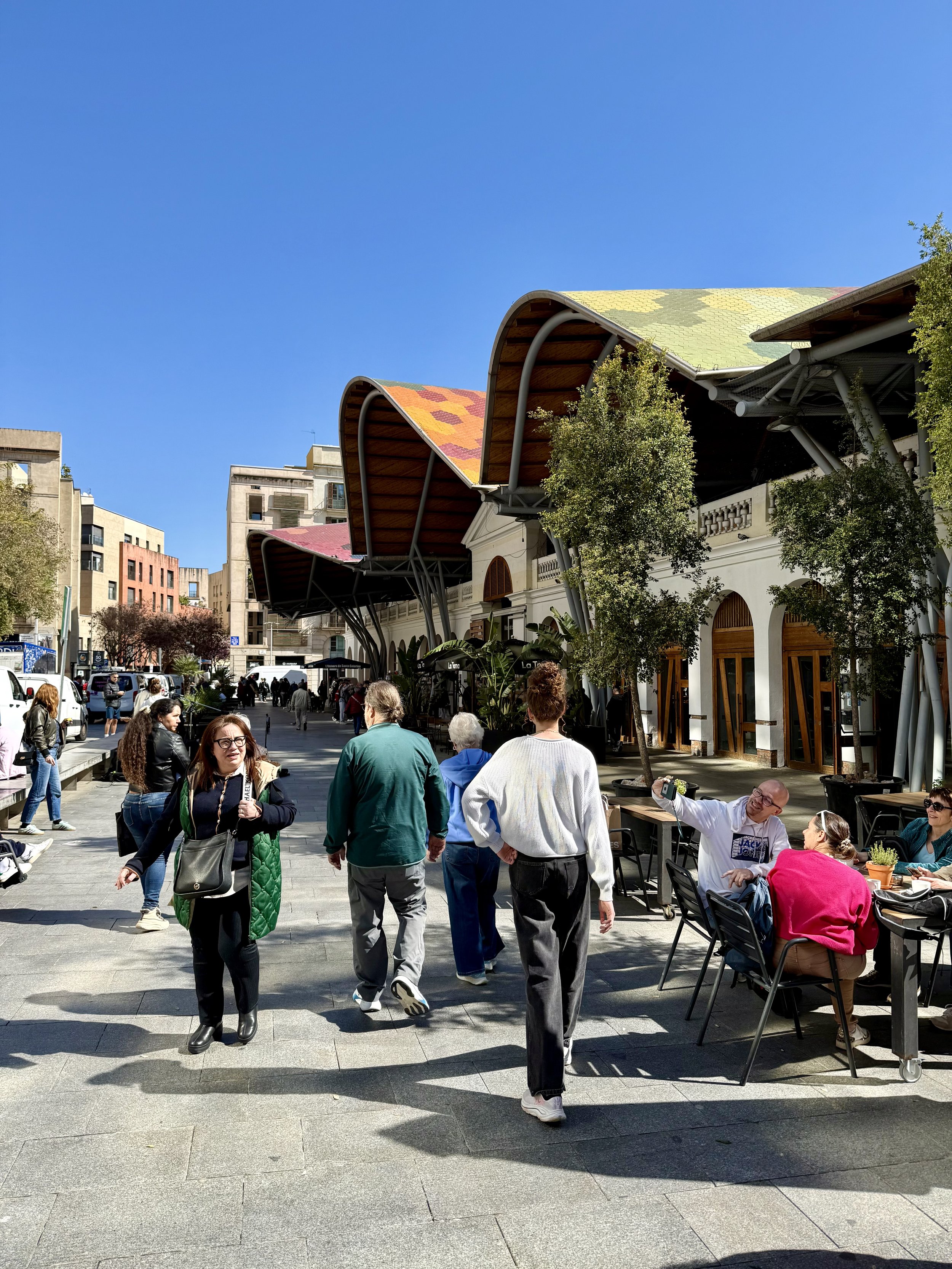 People walking near Mercat de Santa Caterina with distinctive colorful mosaic roof