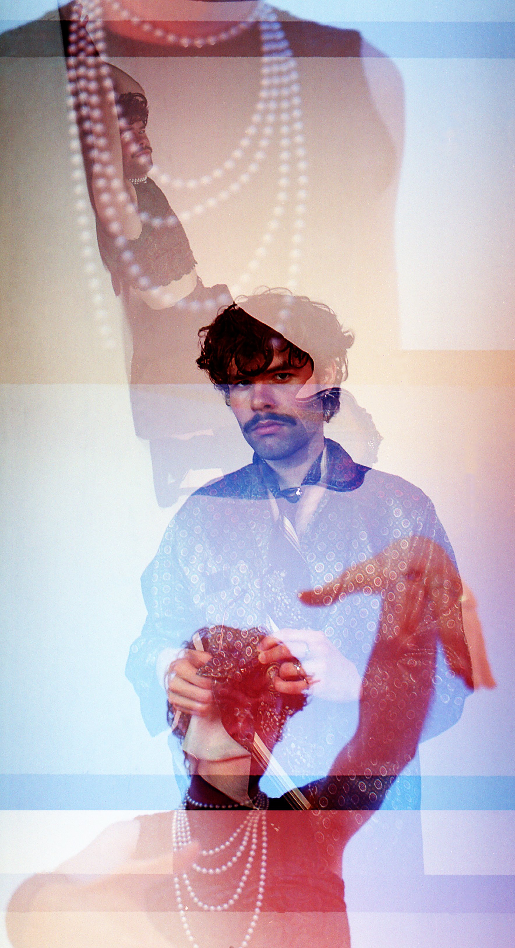 Layered double exposure of a man in a white shirt holding a red flower, pearl necklaces floating over him. Justus Maria album cover by Hartenjager.