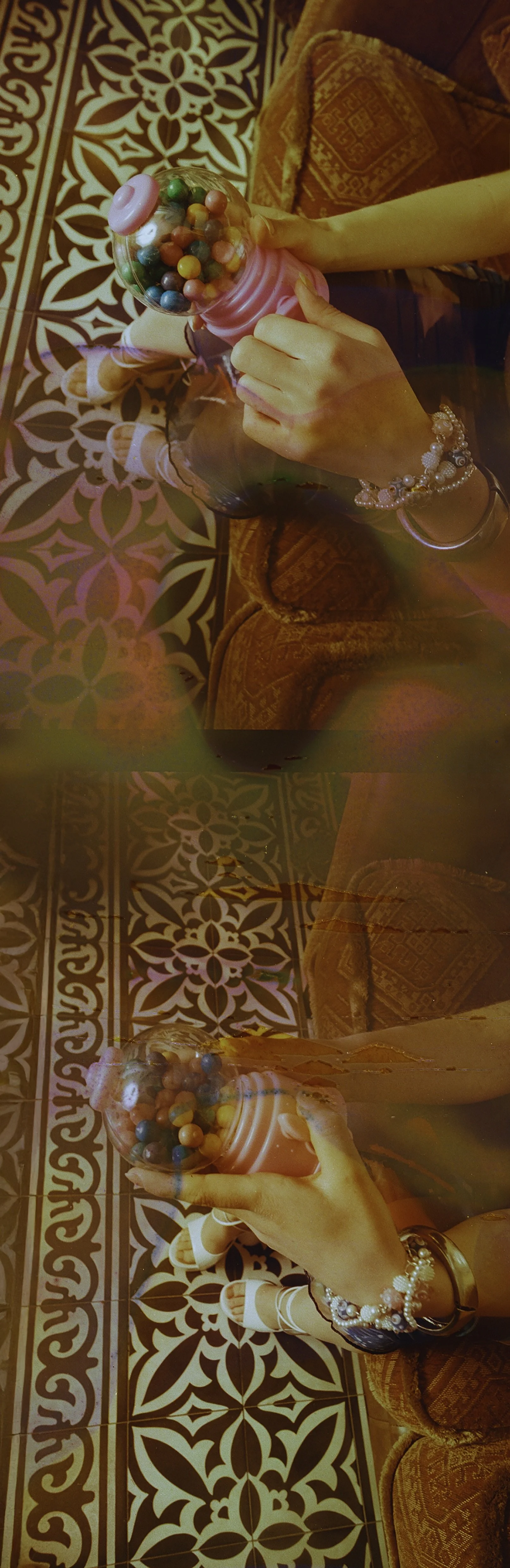 Narrow film strip of a blurred figure on a patterned carpet in warm red tones. Bubblehead by Hartenjager.