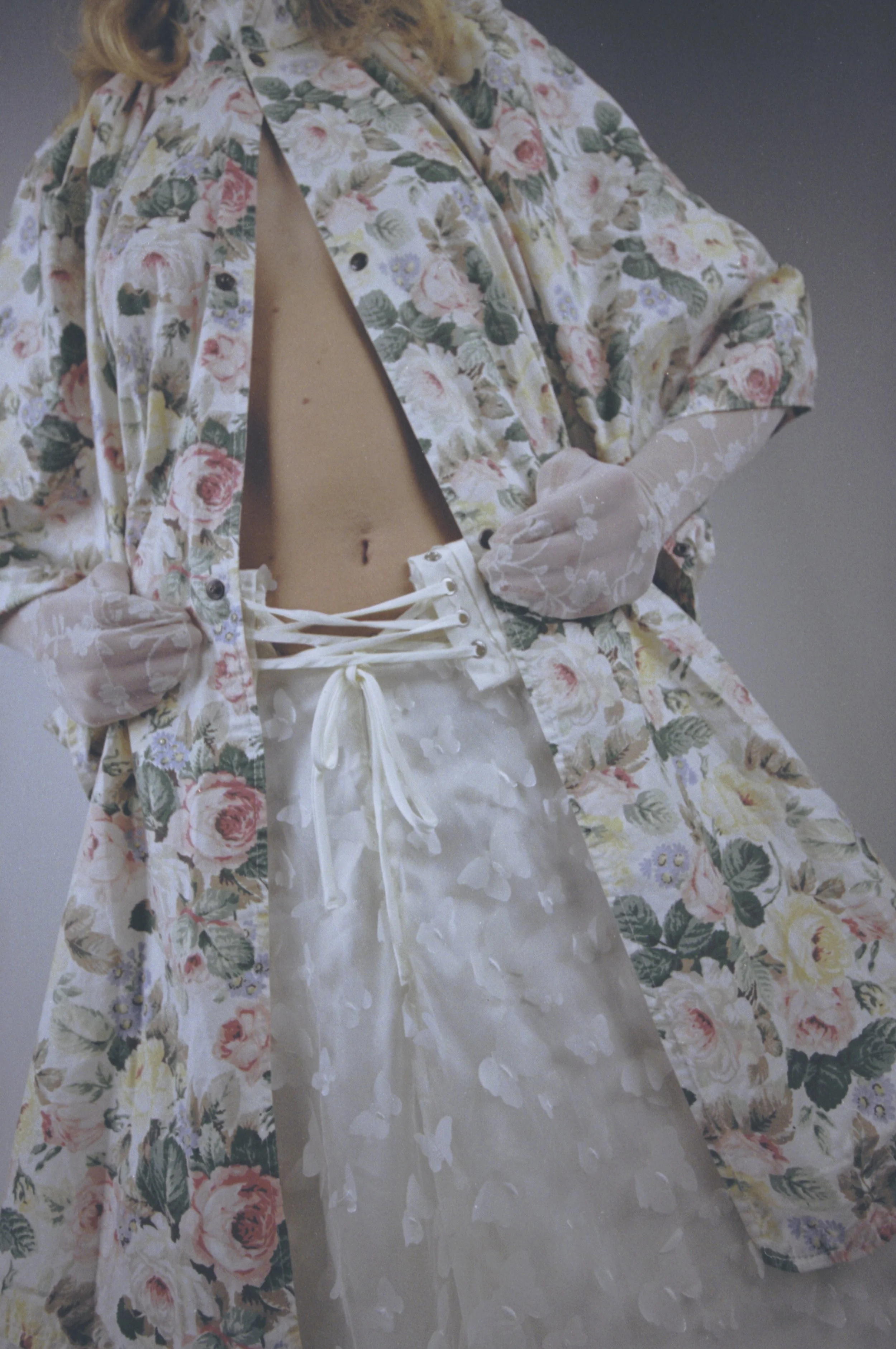 Close-up of a floral coat worn open over a white corset and tulle skirt. Vintáááge January by Hartenjager.