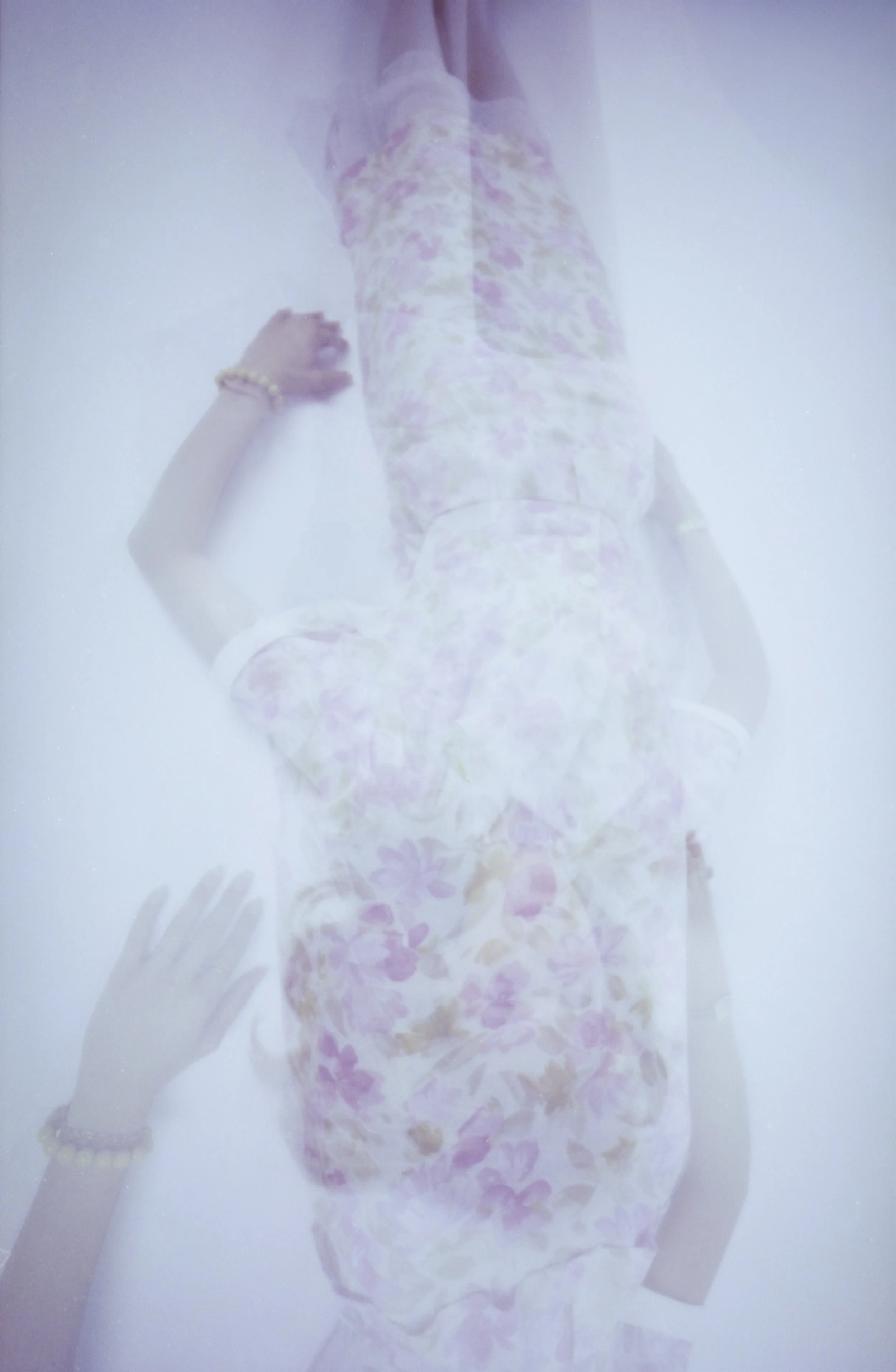 Pale double exposure of a figure in a floral dress, a hand reaching across the frame. My Imaginary Friend by Hartenjager.