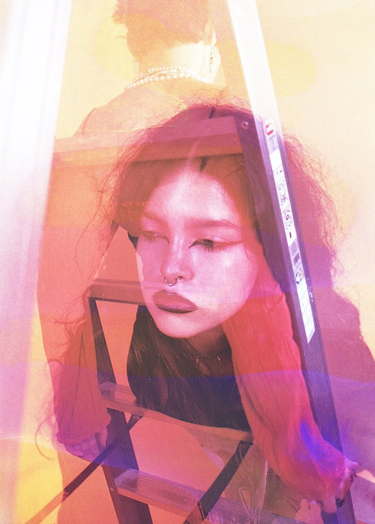 Portrait of a person resting their head on a ladder, overlaid with pink and orange chemical stains. Chemical Subscura by Hartenjager.