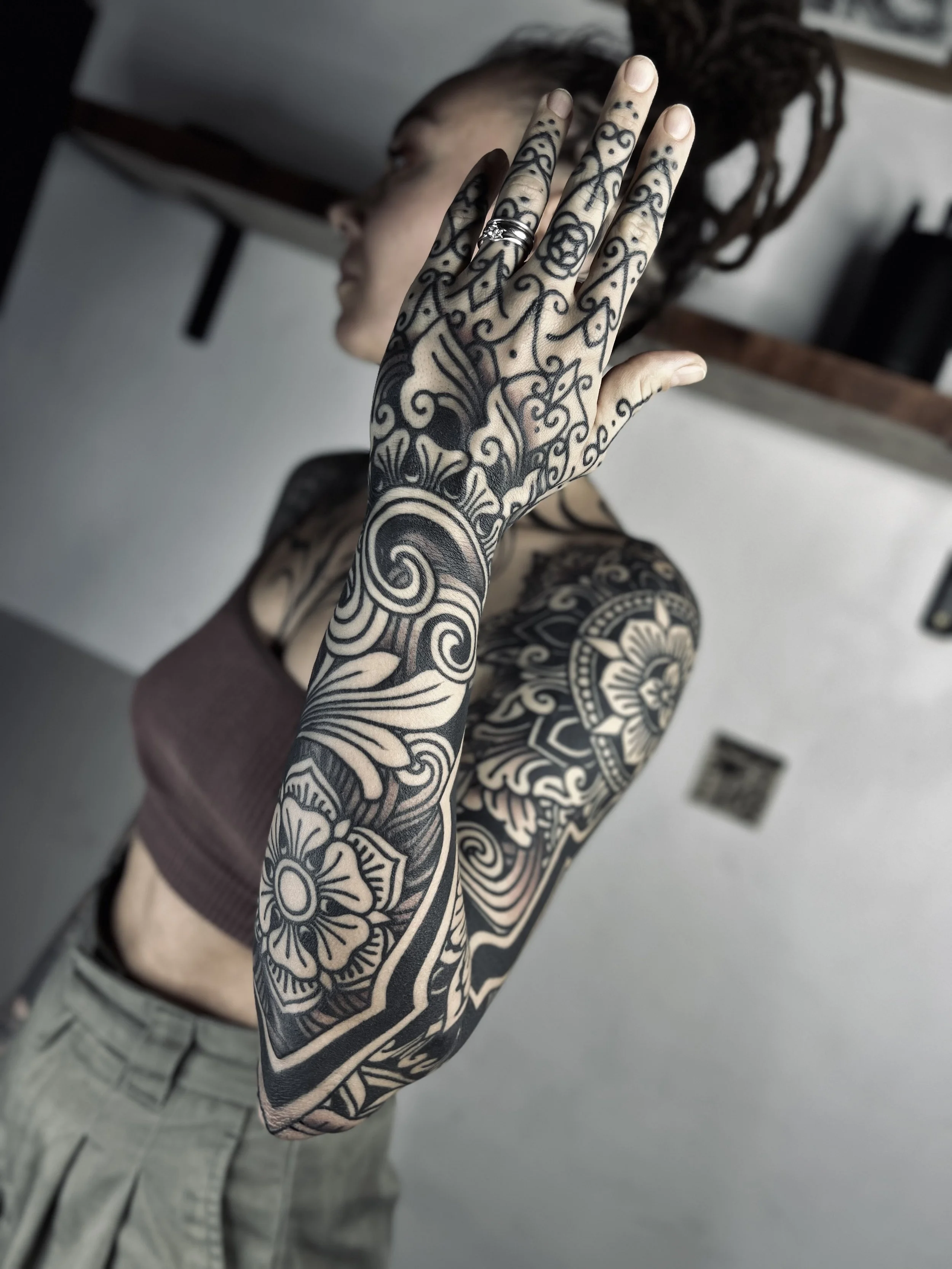 Balinese Ornamental Sleeve tattoo feature floral and ornamental designs in blackwork and dotwork. Covering hand and full arm tattoo, with mandalas and flowers.