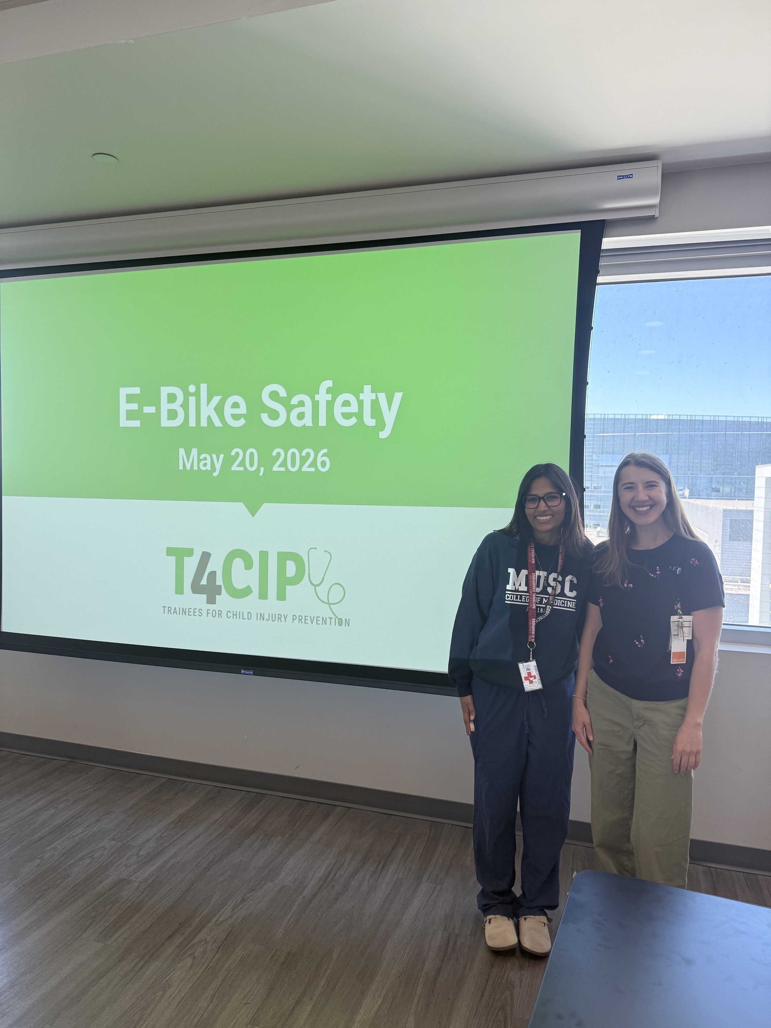 two people standing next to a screen for a presentation
