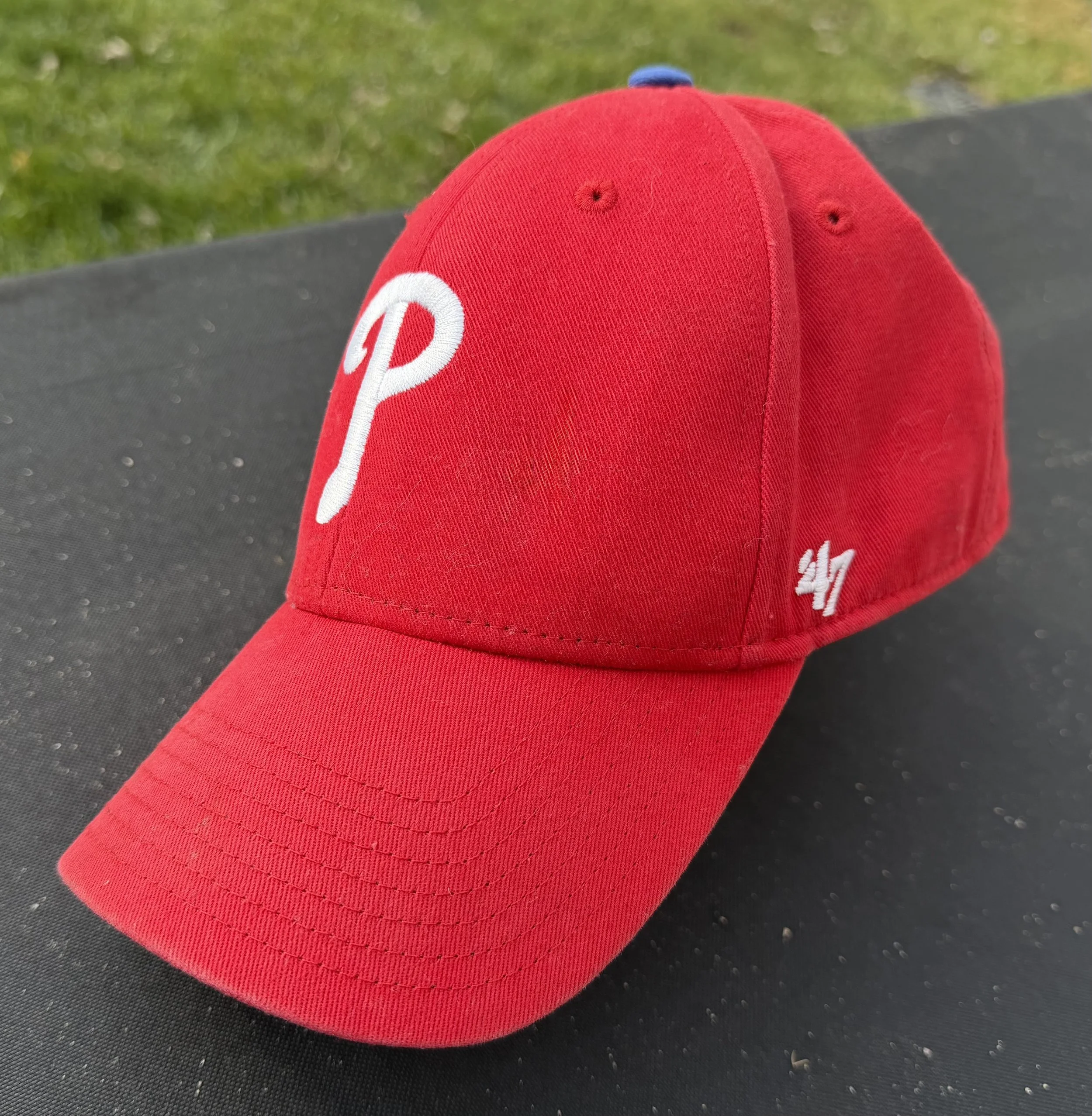 Image of a red Philadelphia Phillies hat, which is made by the brand '47, which also unfortunately corresponds to the number of the current White House resident and his own color of poorly designed hats.