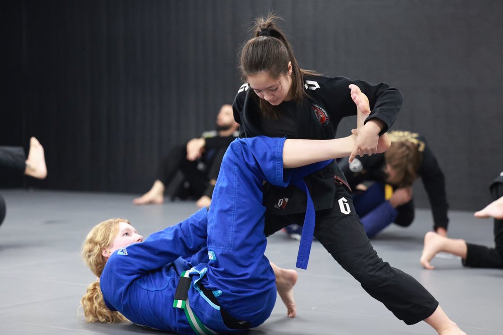 Two students practicing Brazilian Jiu-Jitsu in gis