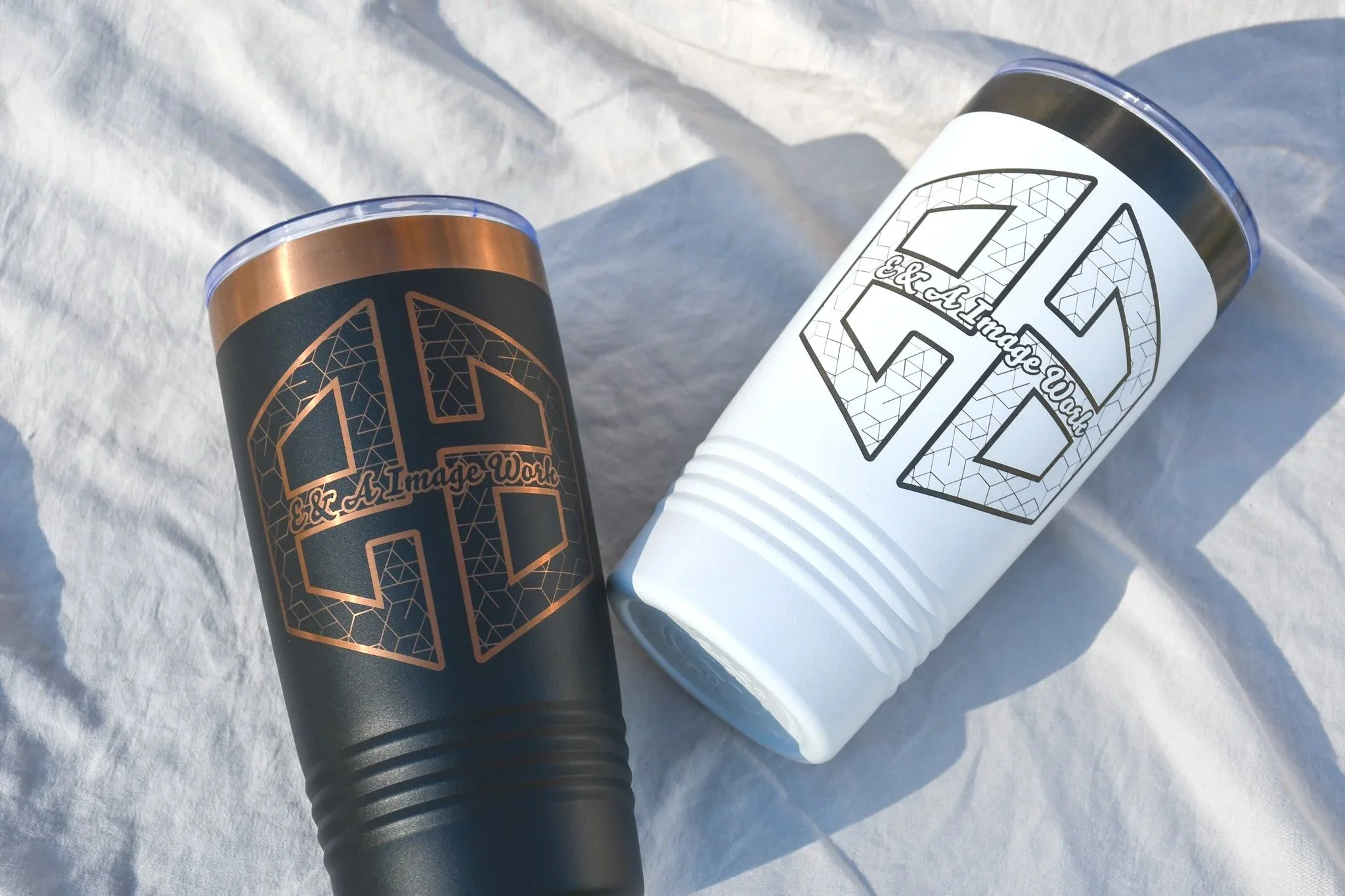 Two cups with black and white designs, featuring geometric patterns and the text '& A Image Work'.