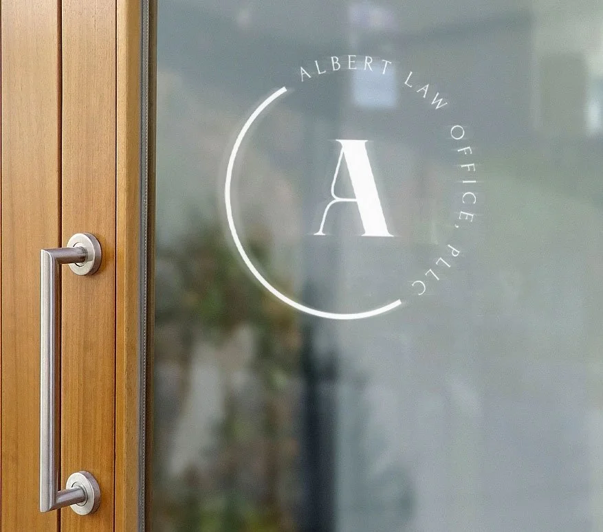 Glass door with a logo that reads 'Albert Law Office PLLC' surrounding a large letter 'A' in the center.