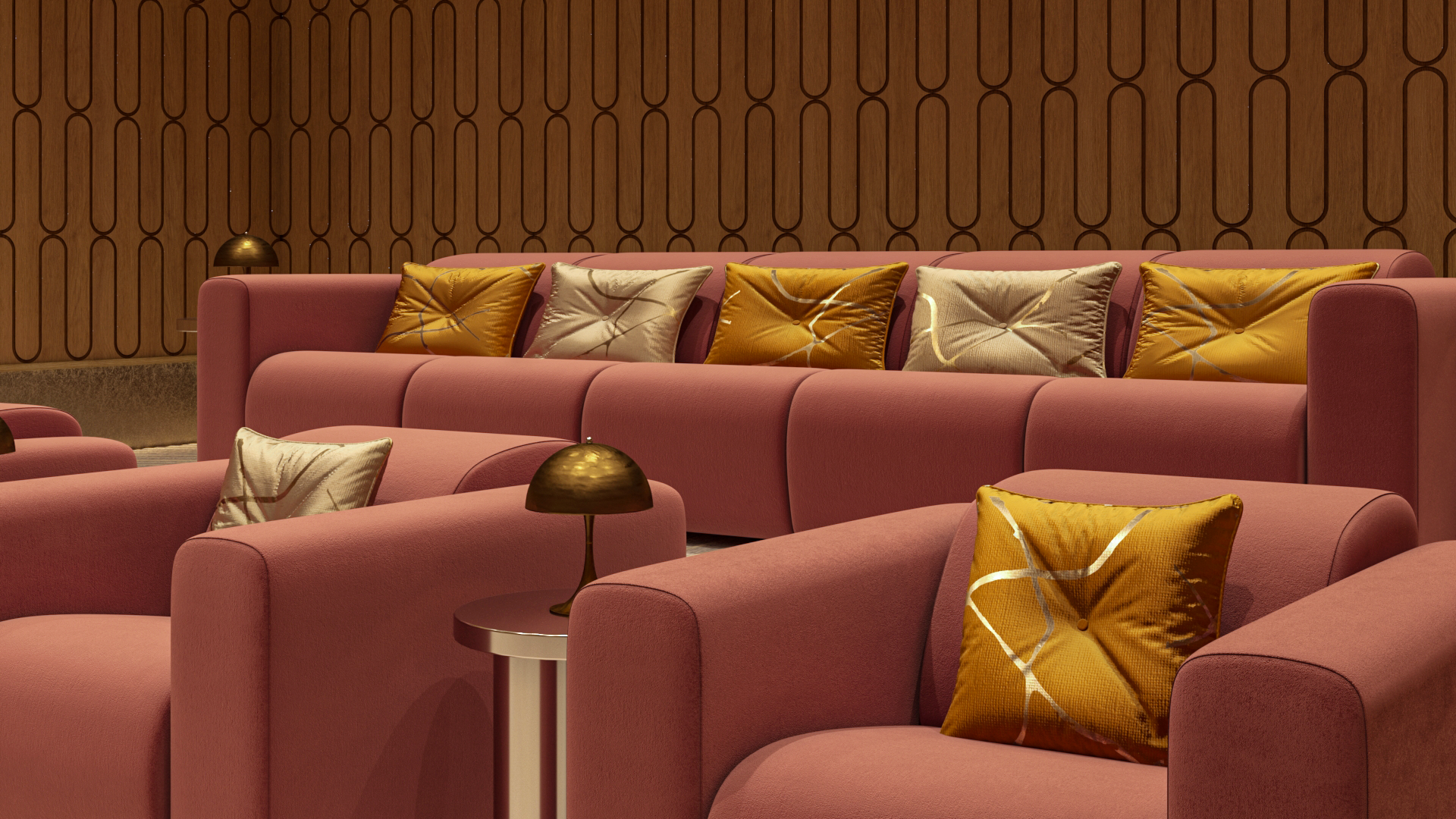 A modern lounge area with pink upholstered armchairs and sofas, adorned with gold and beige decorative pillows. There are small brass table lamps on side tables, and the background features a wooden wall with a repeating geometric pattern.