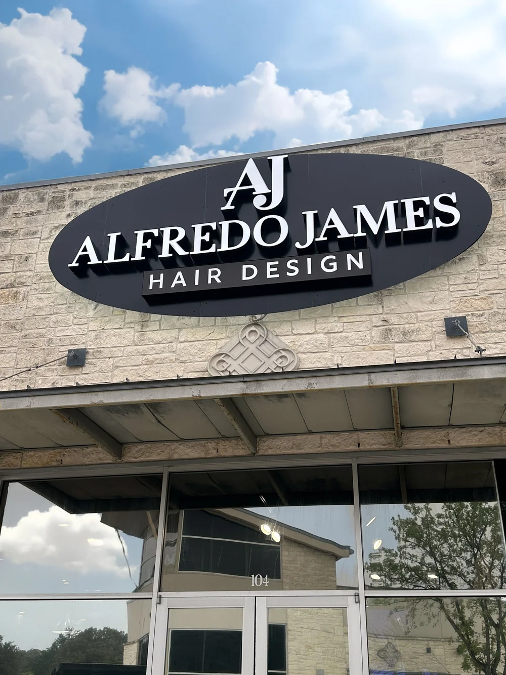 El letrero de Alfredo James Hair Design sobre el salón de Stone Oak en Blanco Road