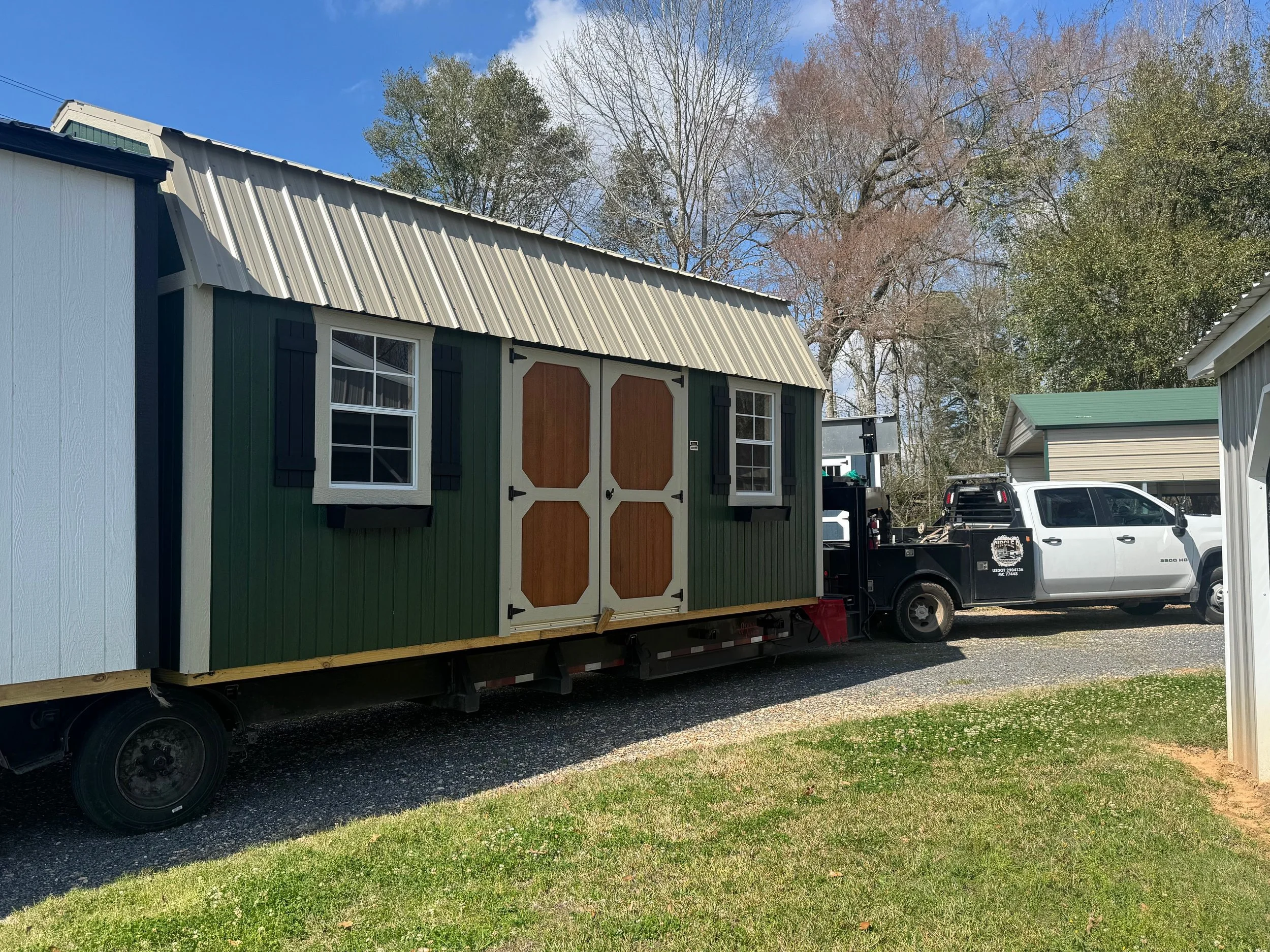 A Graceland Portable Building ready for delivery and loaded on a customized trailer with specialized equipment. 10'x20' Side Lofted Barn Signature Series