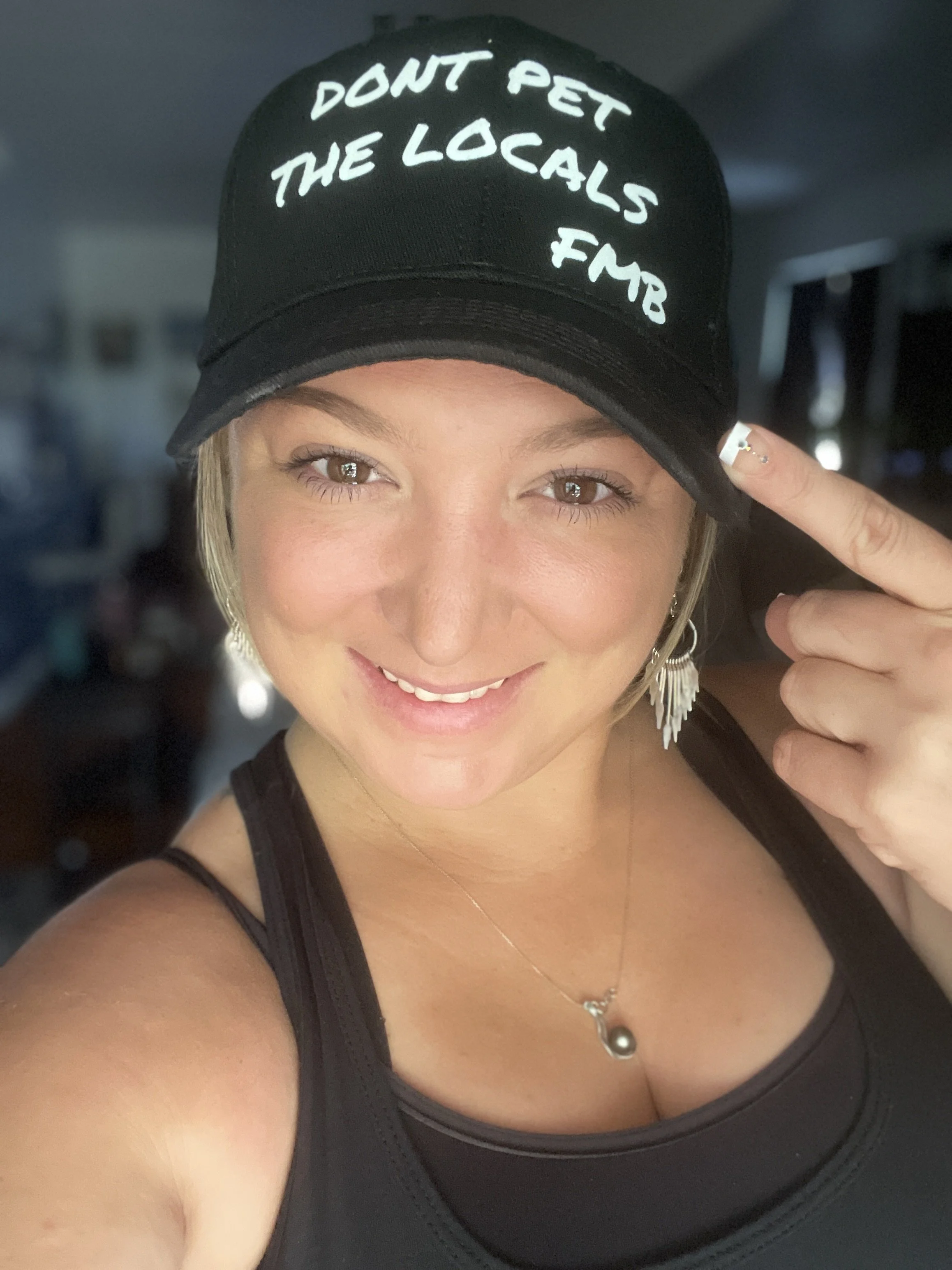 Woman wearing a black Don’t Pet the Locals hat