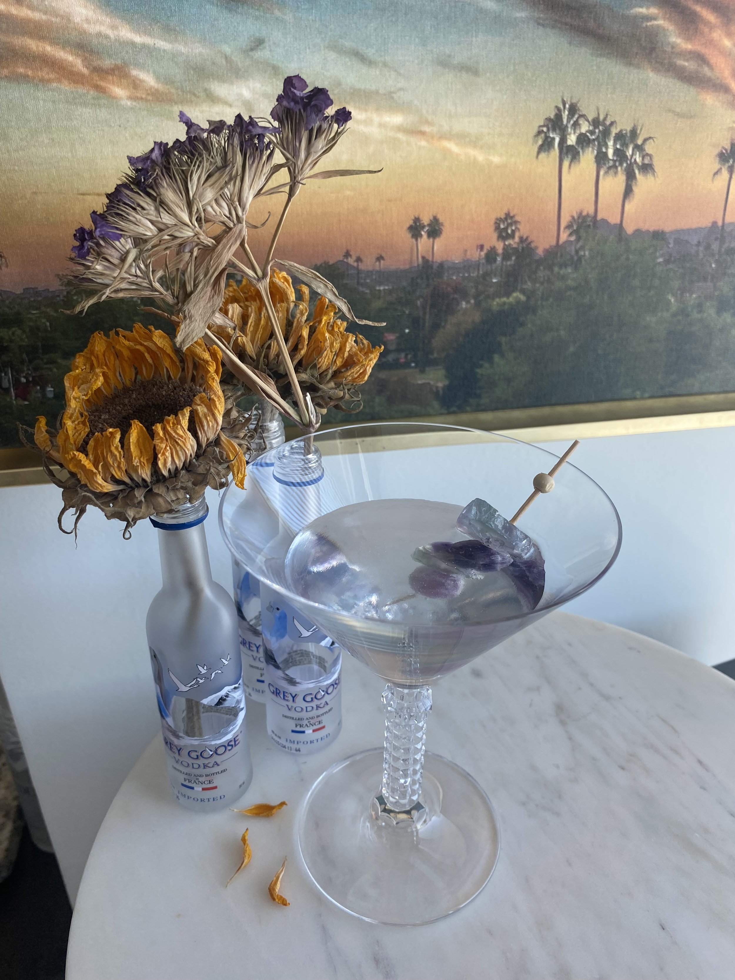 Fancy martini with purple rocks and bottles with flowers.jpeg